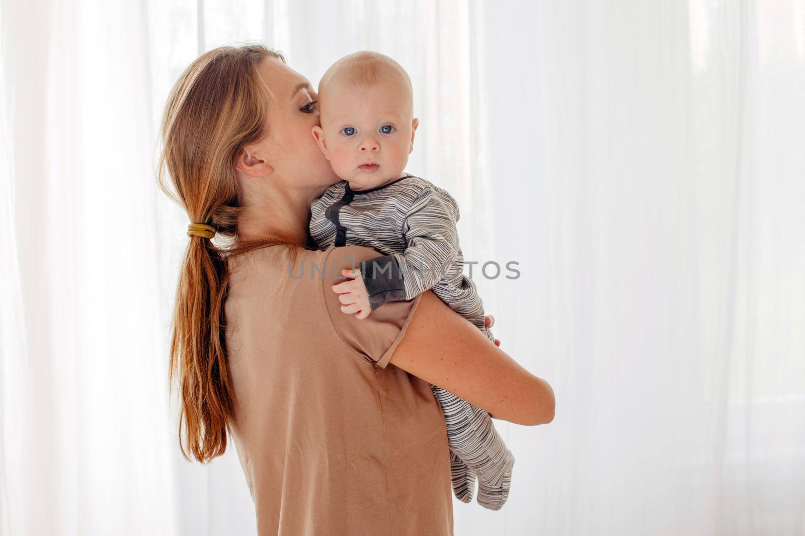 Close up portrait of beautiful young mother kissing her newborn baby. Healthcare and medical love lifestyle mother's day concept