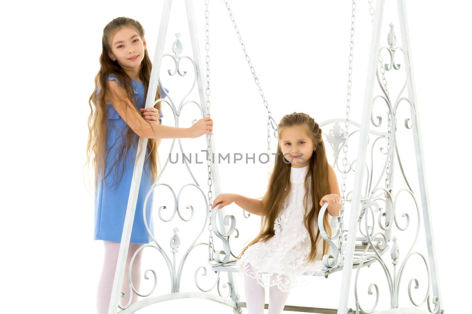Funny little girls swing on a swing. The concept of a good mood, a happy childhood. Isolated on white background.