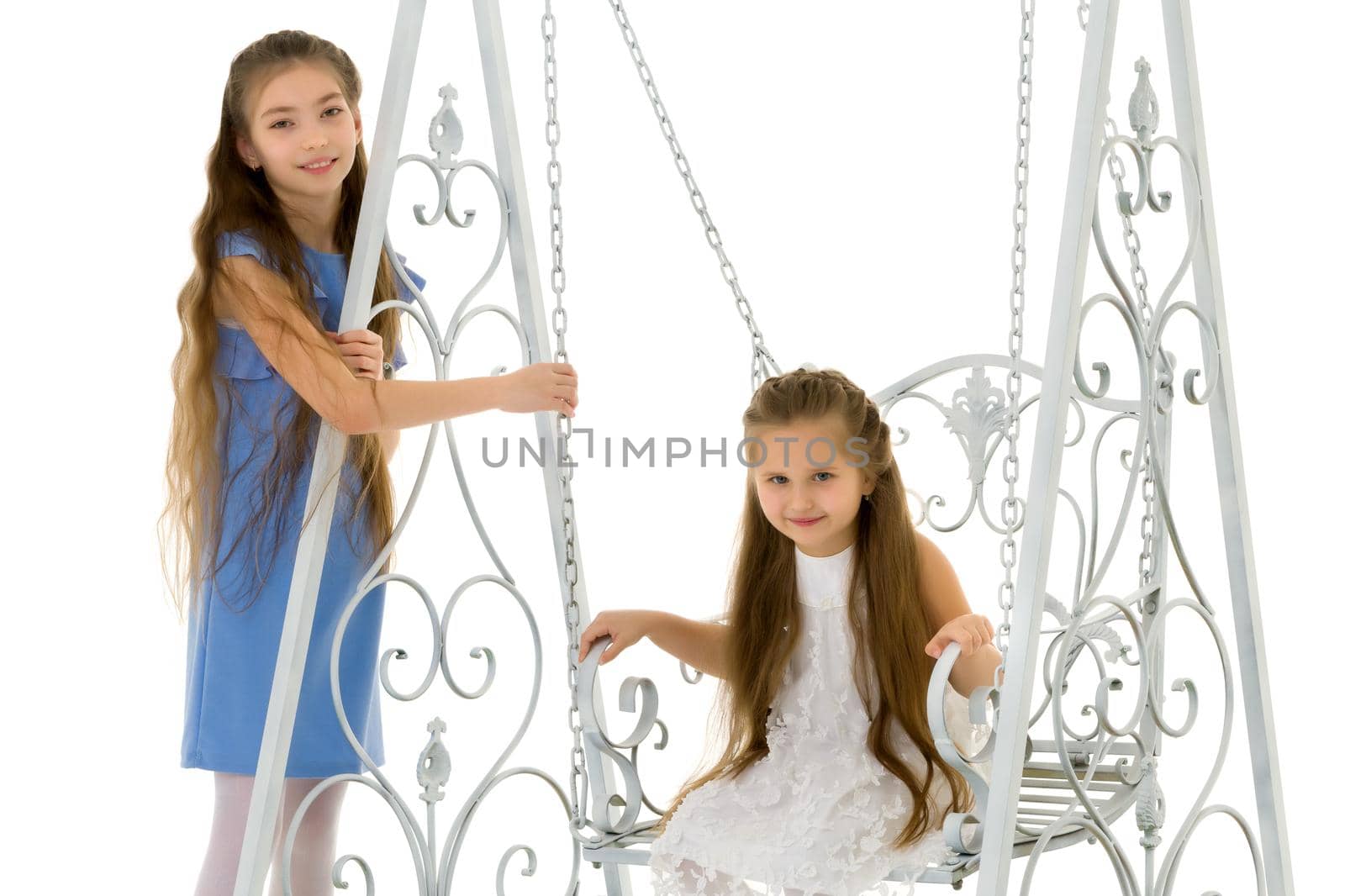 Funny little girls swing on a swing. The concept of a good mood, a happy childhood. Isolated on white background.