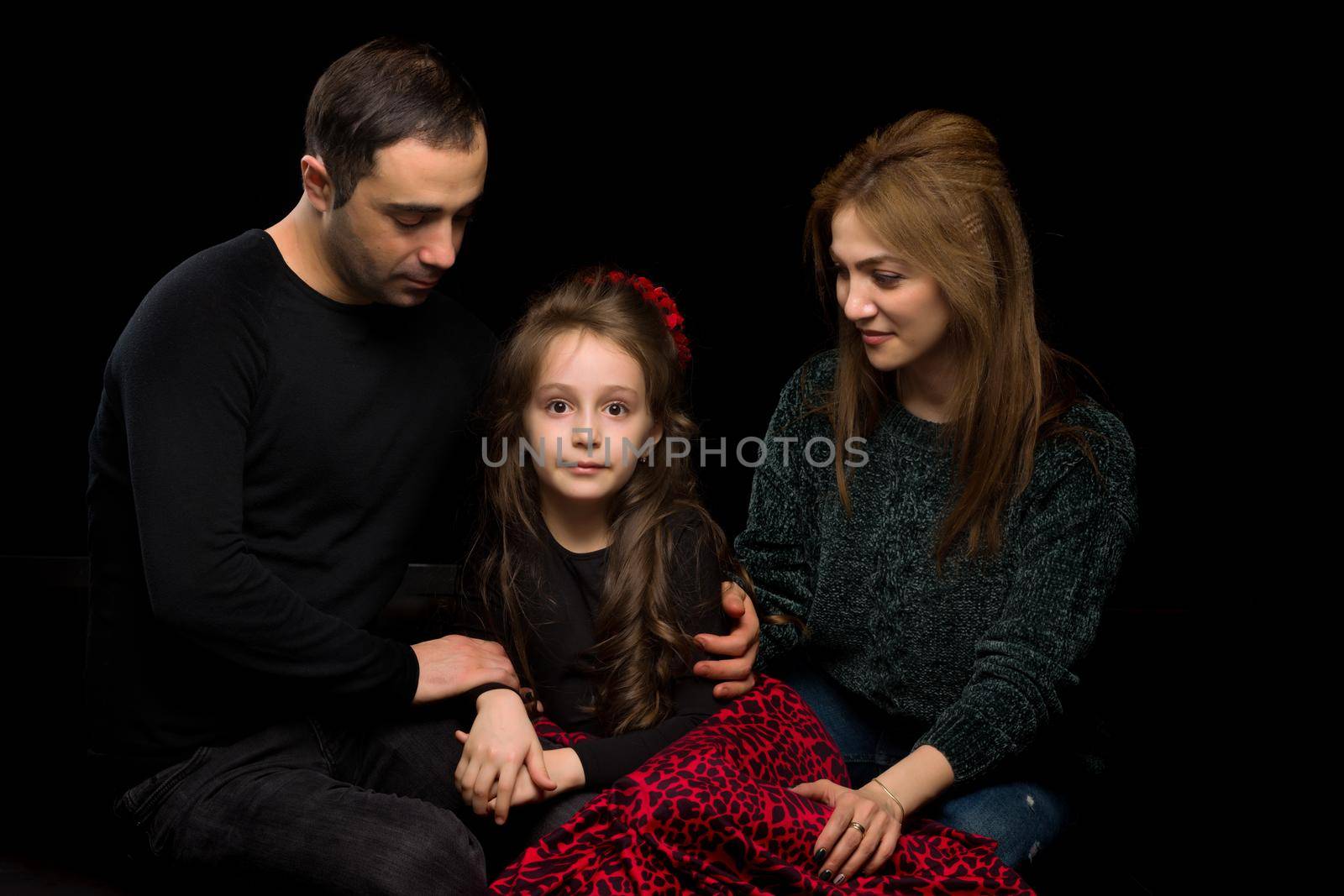 Portrait of Loving Parents Hugging their Adorable Daughter by kolesnikov_studio