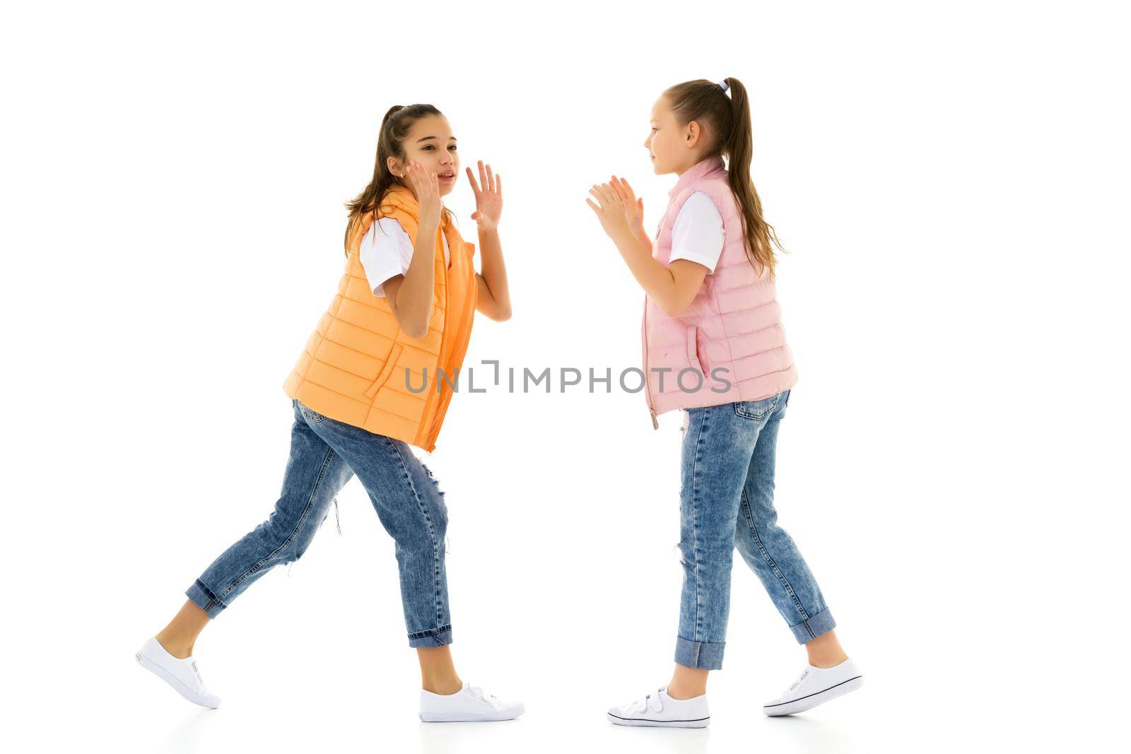 Two girls telling a secret and expressing surprise isolated on white