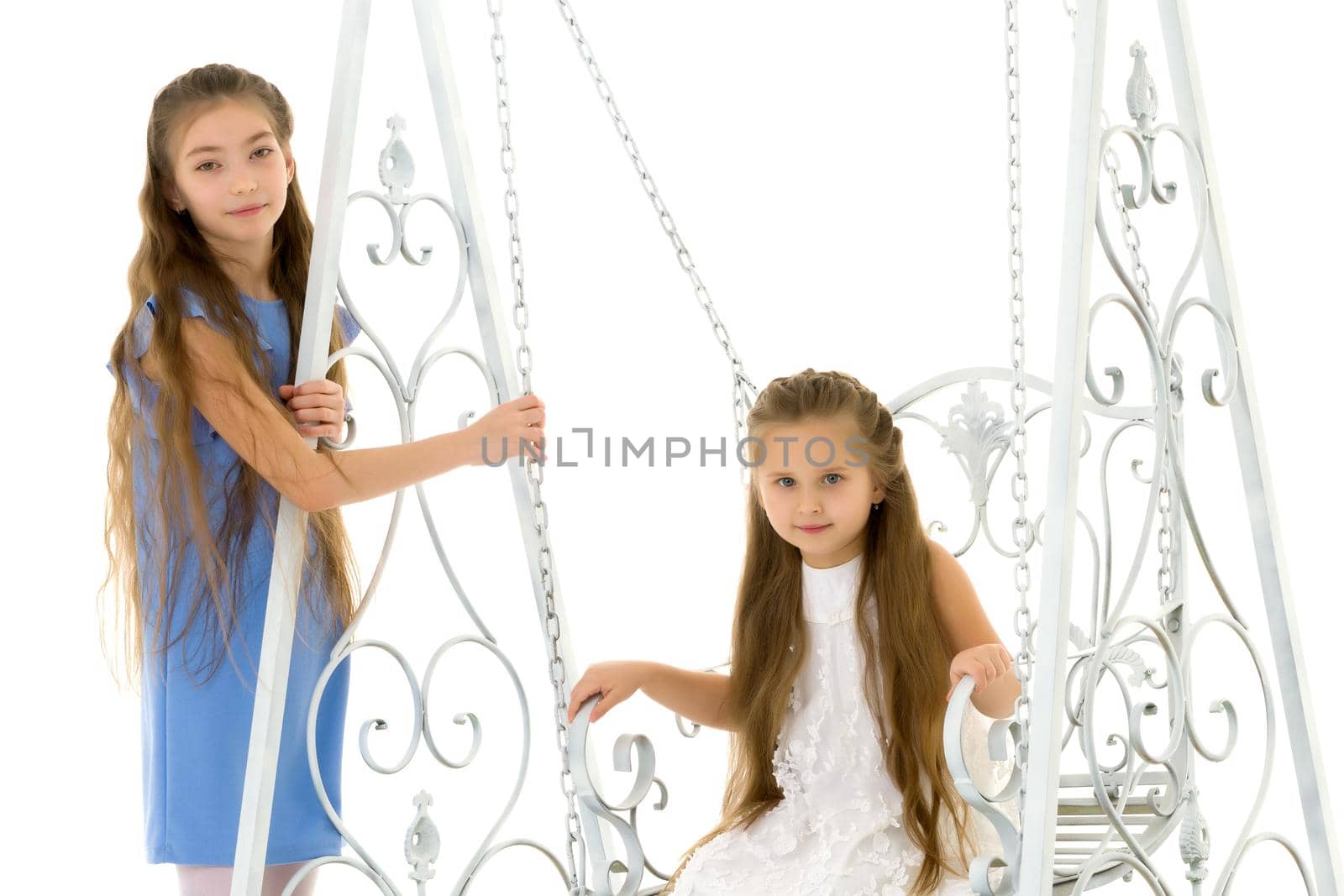 Funny little girls swing on a swing. The concept of a good mood, a happy childhood. Isolated on white background.