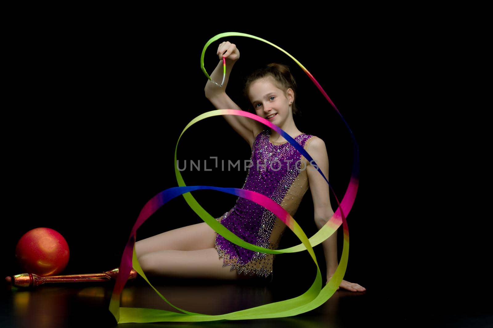 Beautiful little girl gymnast performs exercises with the ball. The concept of children's sports, fitness. Isolated.