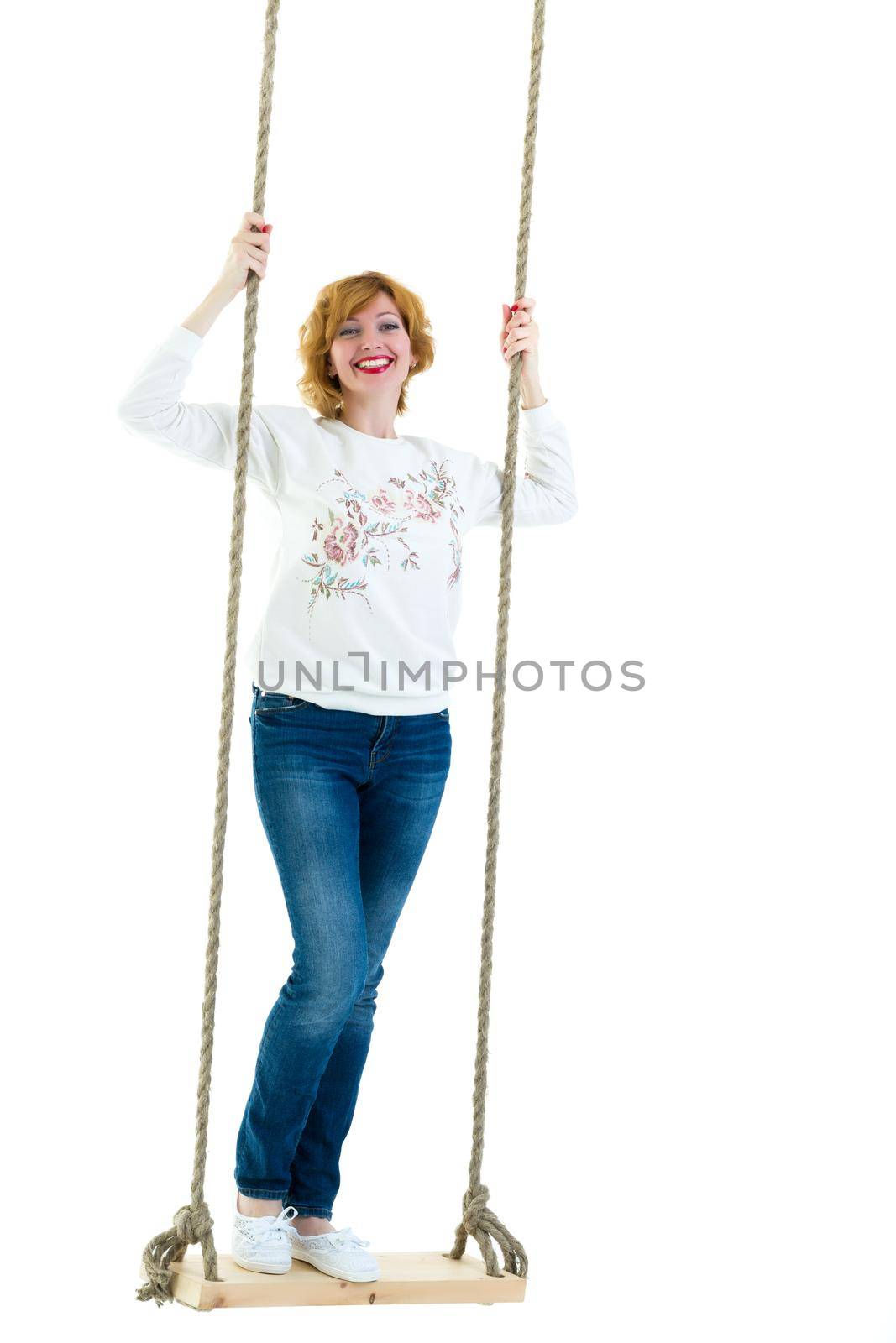 beautiful young woman on a swing against white studio background. by kolesnikov_studio