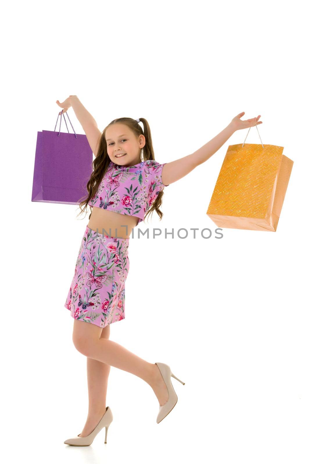 Little girl with multi-colored bags in their hands. by kolesnikov_studio
