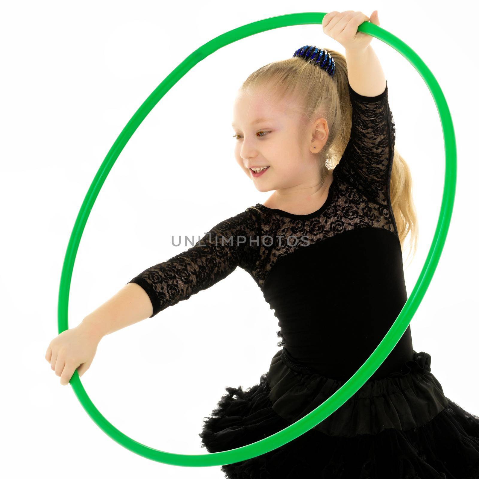 Happy little girl playing with a hoop. The concept of a happy childhood. Isolated on white background.