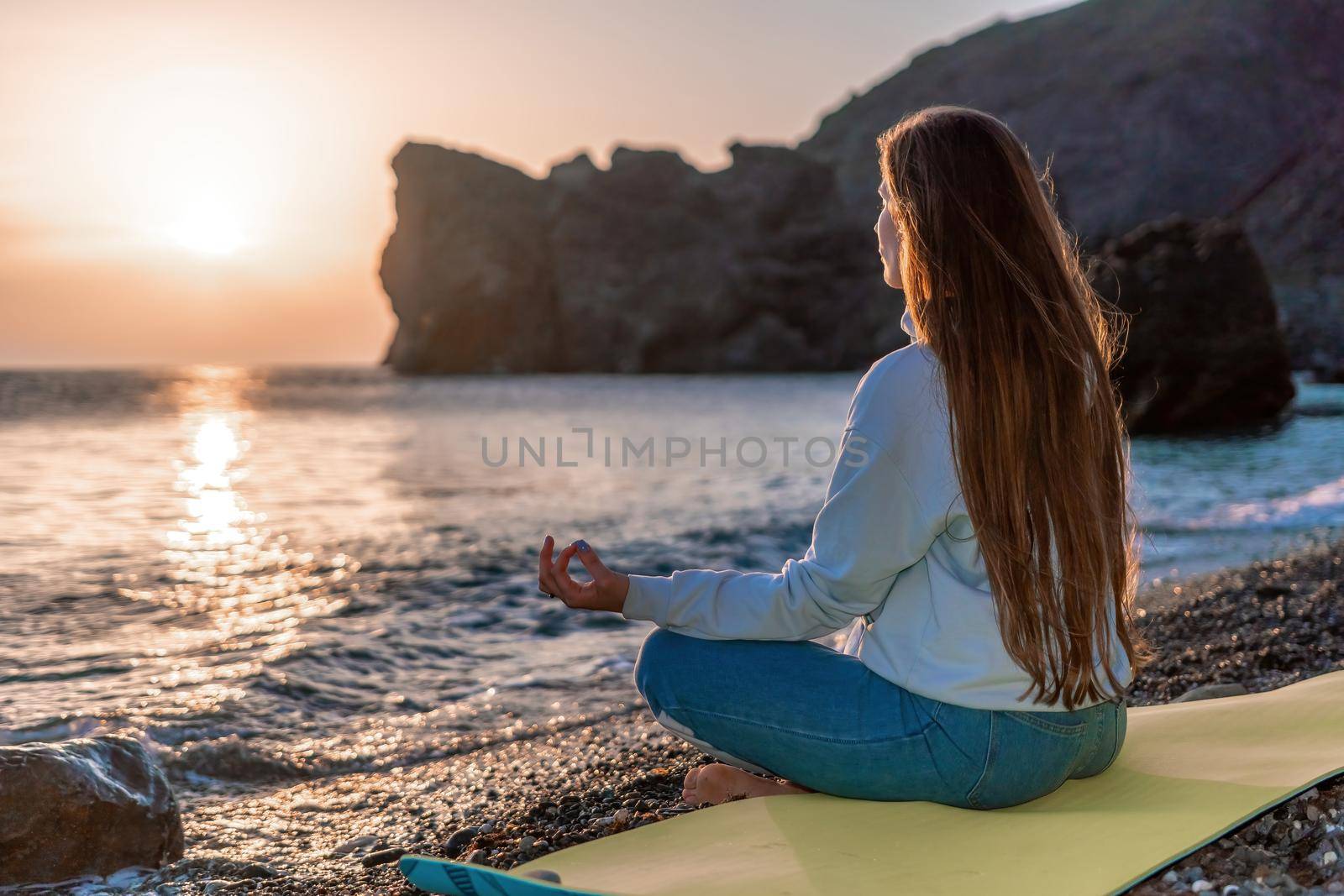 woman traveler drinks coffee with a view of the mountain landscape. A young tourist woman drinks a hot drink from a cup and enjoys the scenery in the mountains. Trekking concept