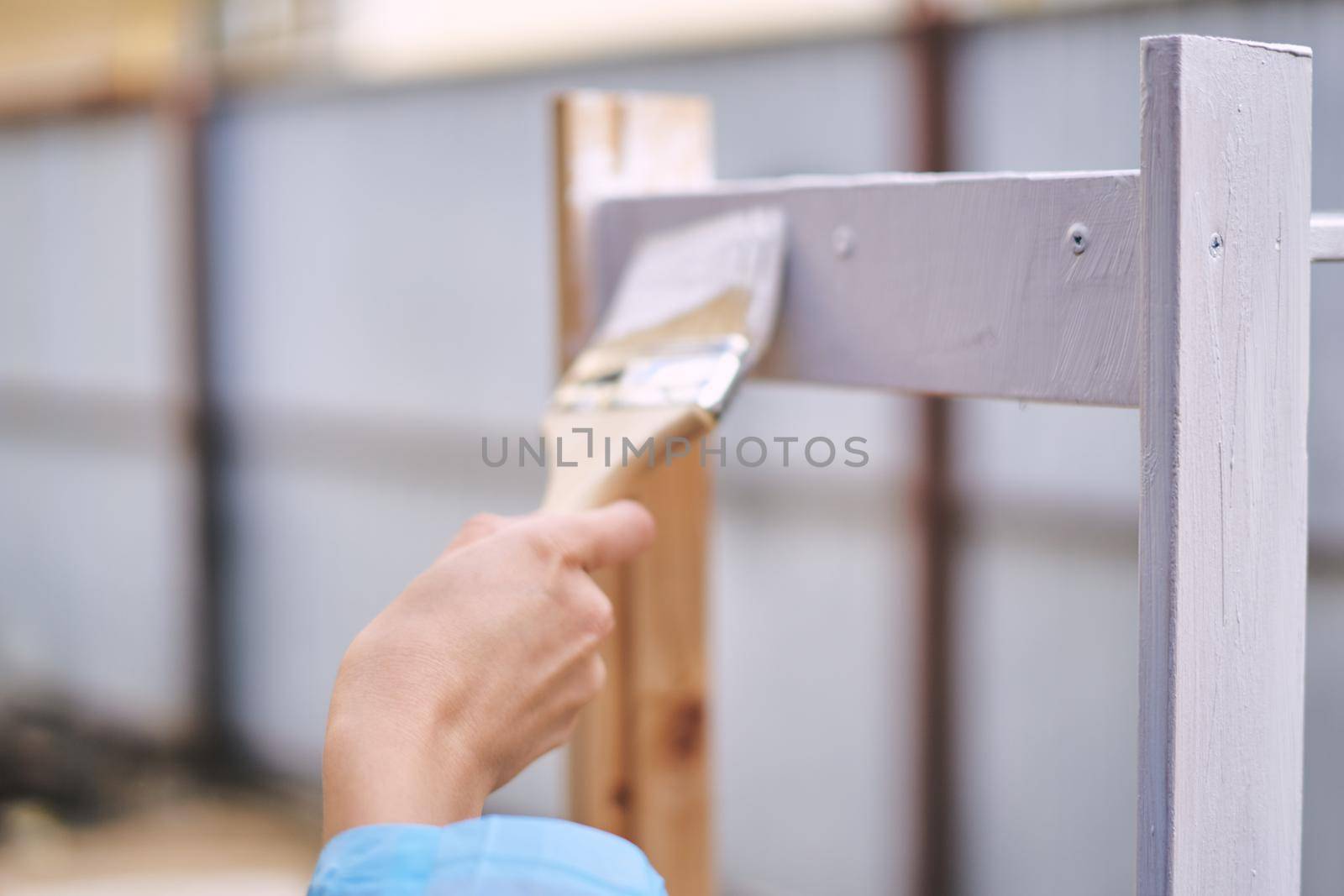 woman house painter renovating wood fittings at home by Vichizh