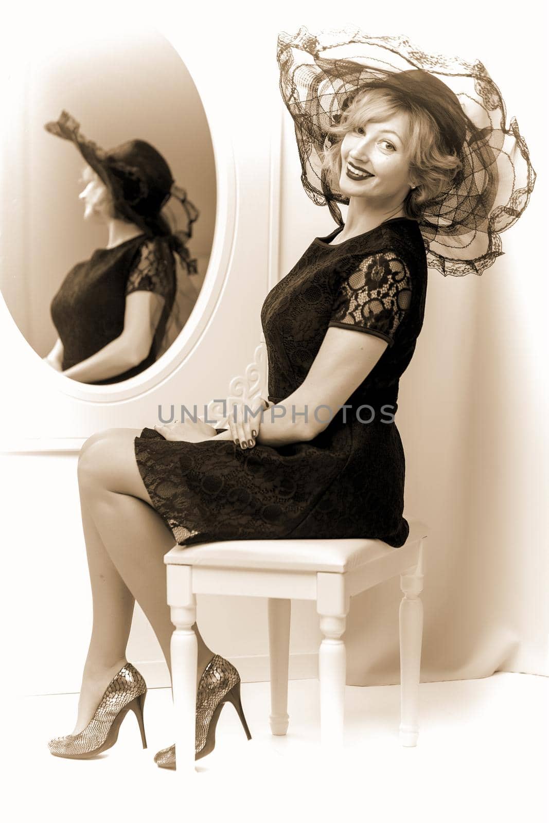 Retro portrait of a beautiful woman next to mirror. Vintage Styl by kolesnikov_studio
