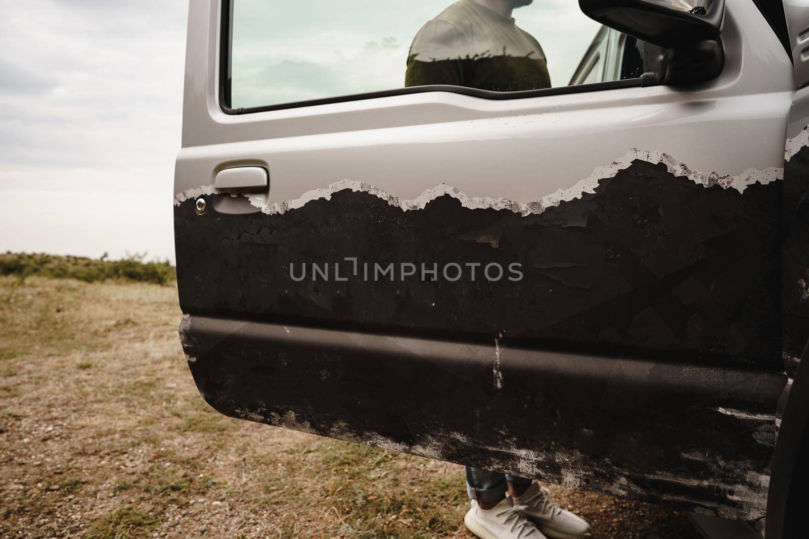 Gray off-road car stopped with open door, close up
