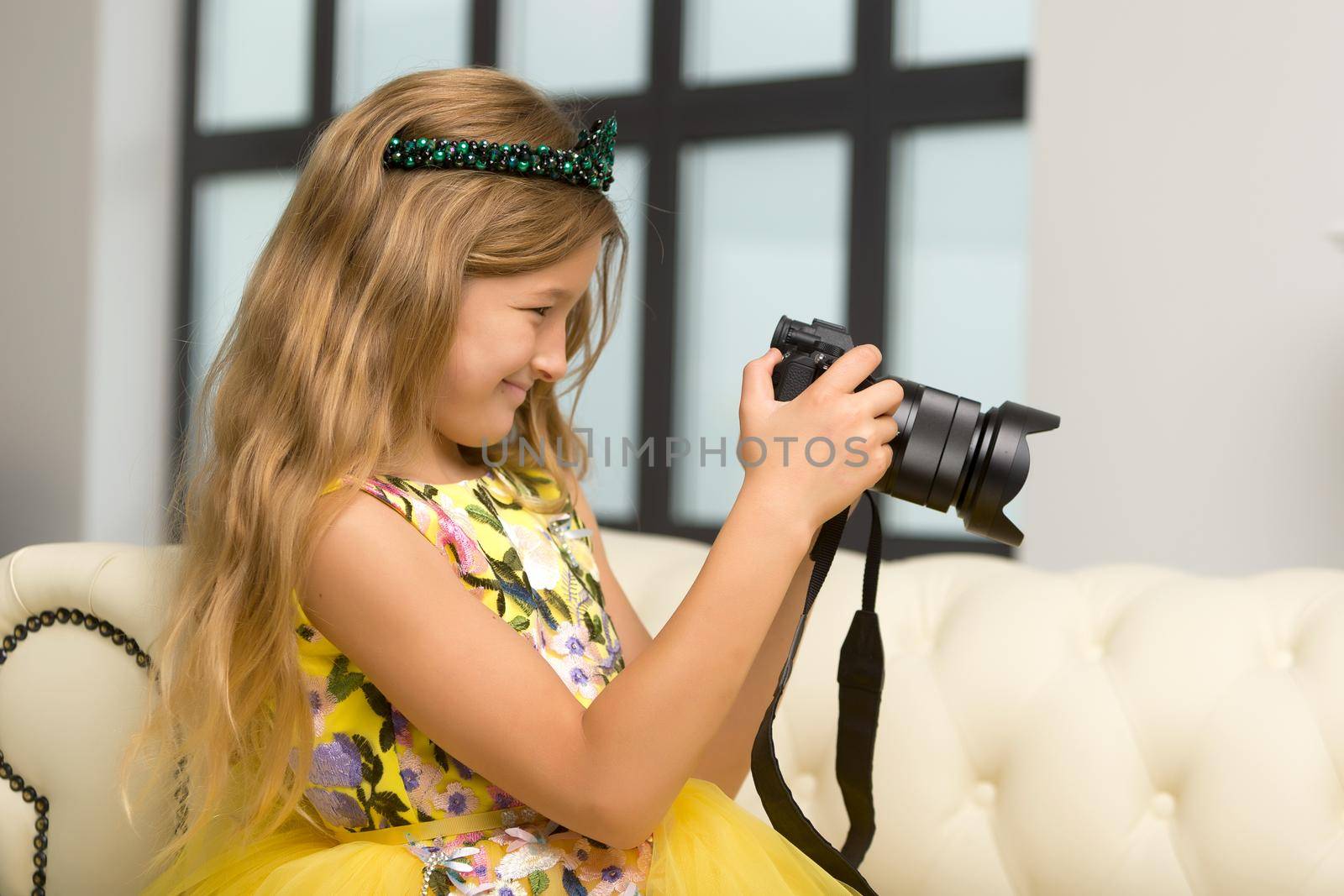 Cute little girl is studying her camera. The concept of children's creativity.