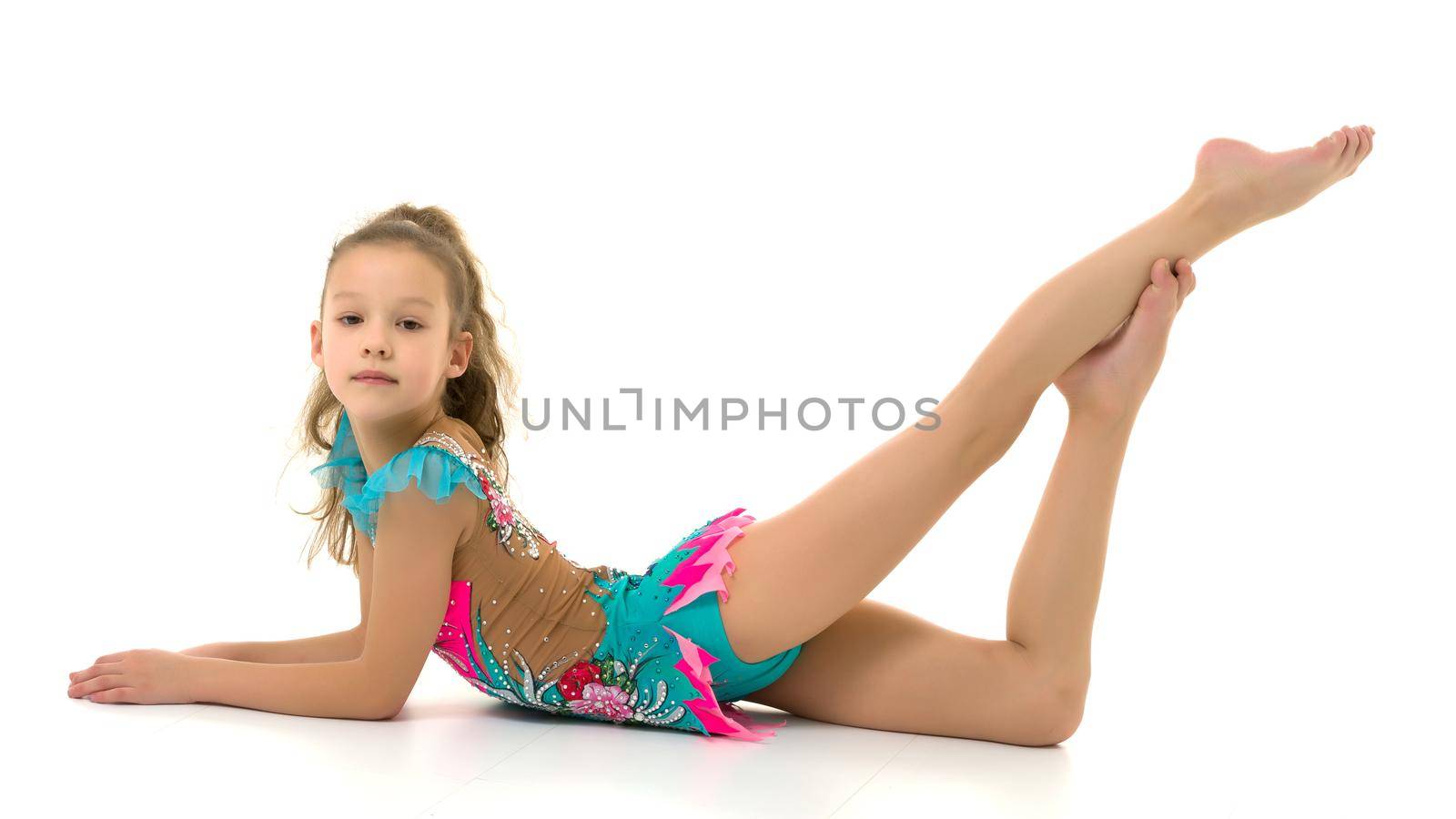 Charming little girl doing gymnastic exercises in the studio on a white background by kolesnikov_studio