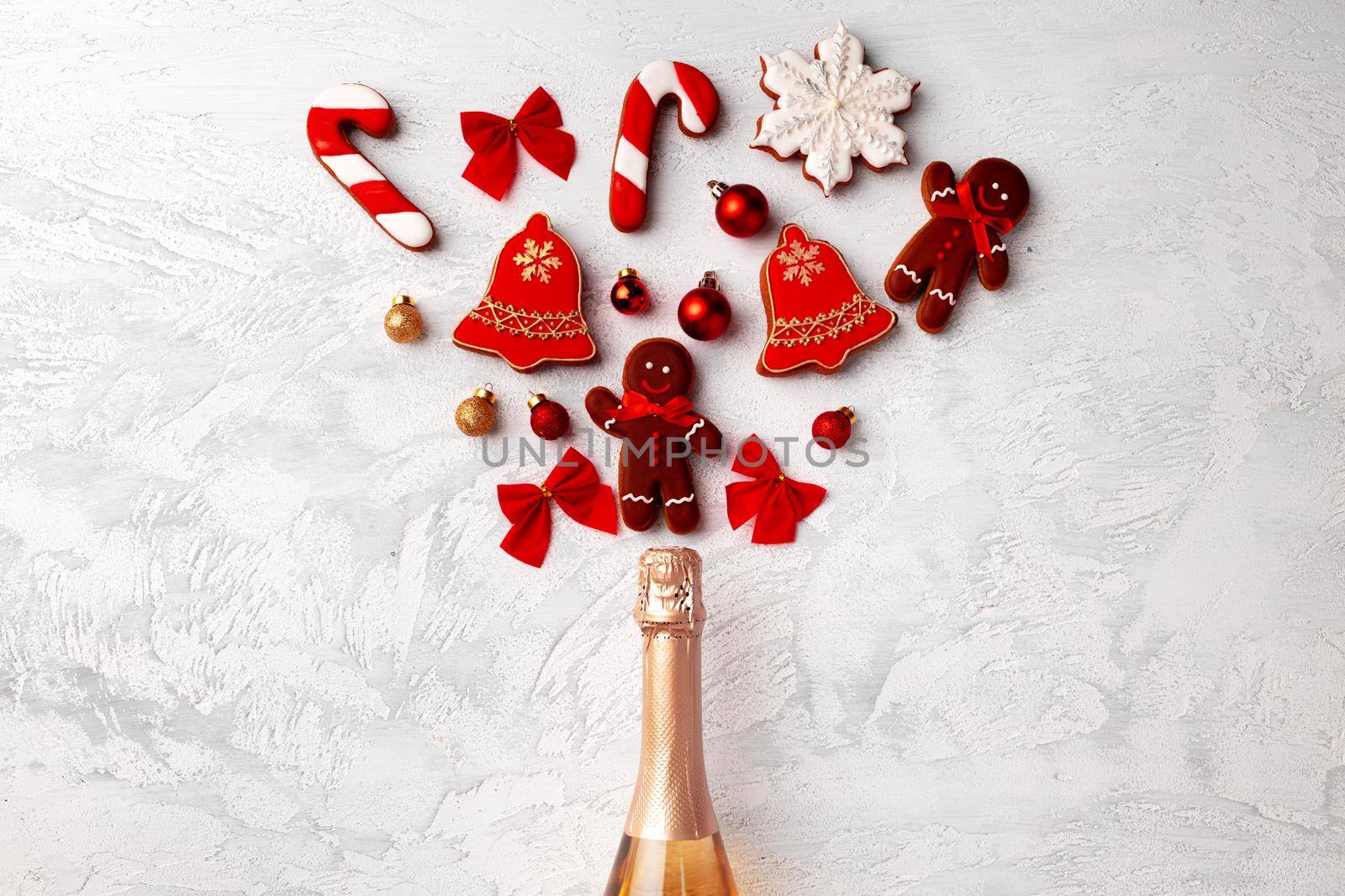 Golden champagne bottle with Christmas gingerbread flatlay top view