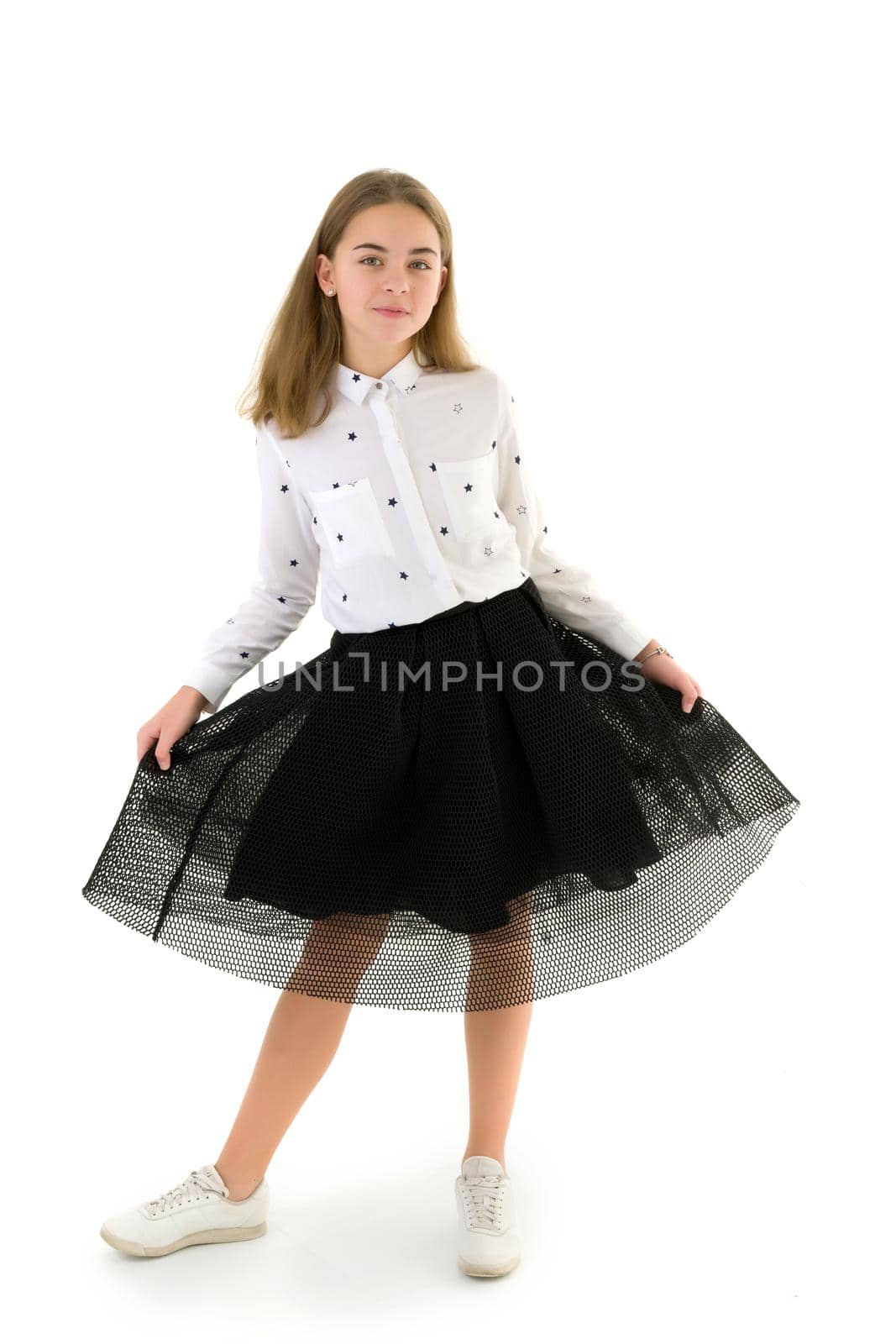 Beautiful little girl in an elegant dress holds her hands around the edges of the skirt. Isolated on white.