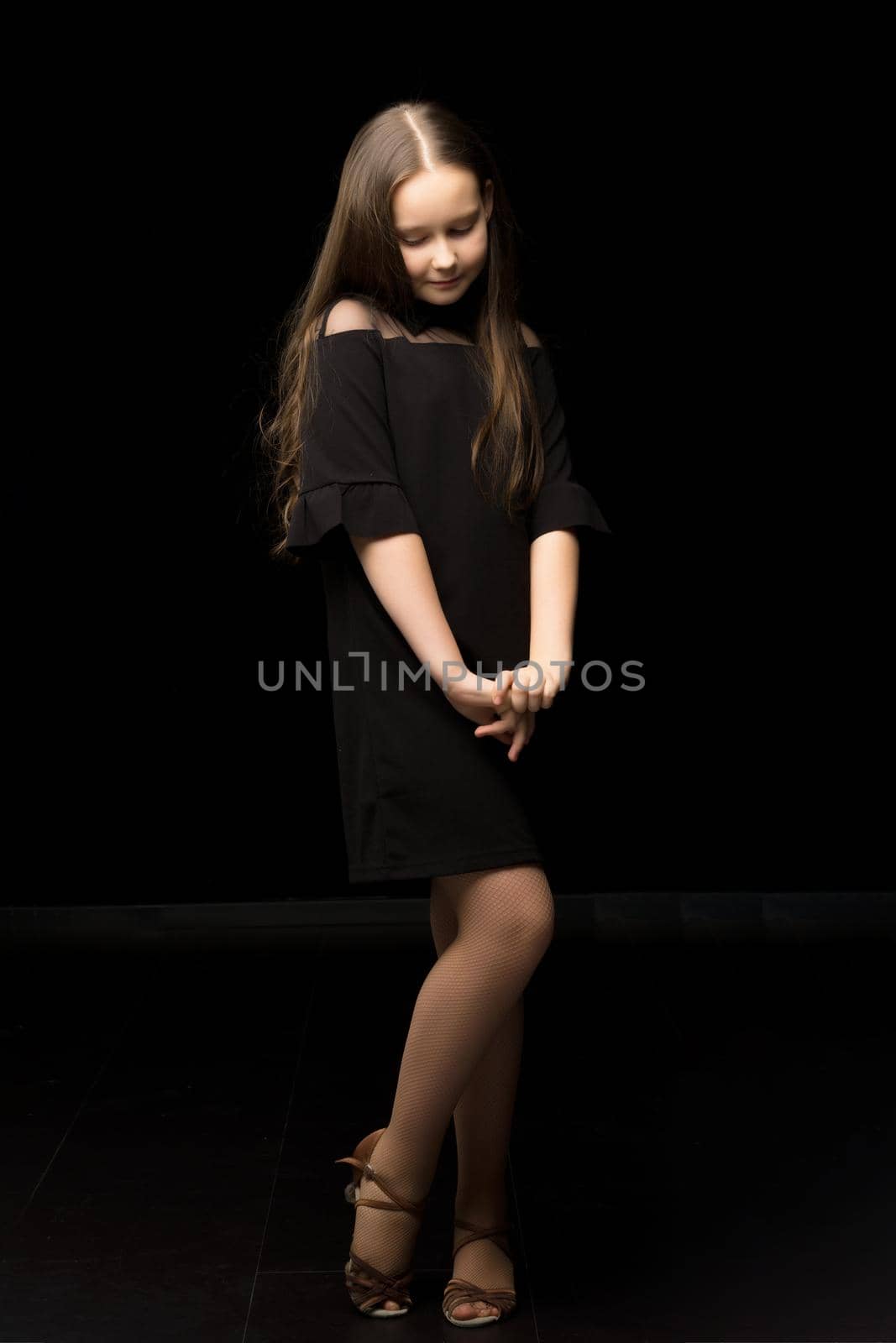 Cute little girl in a beautiful dress on a black background. by kolesnikov_studio