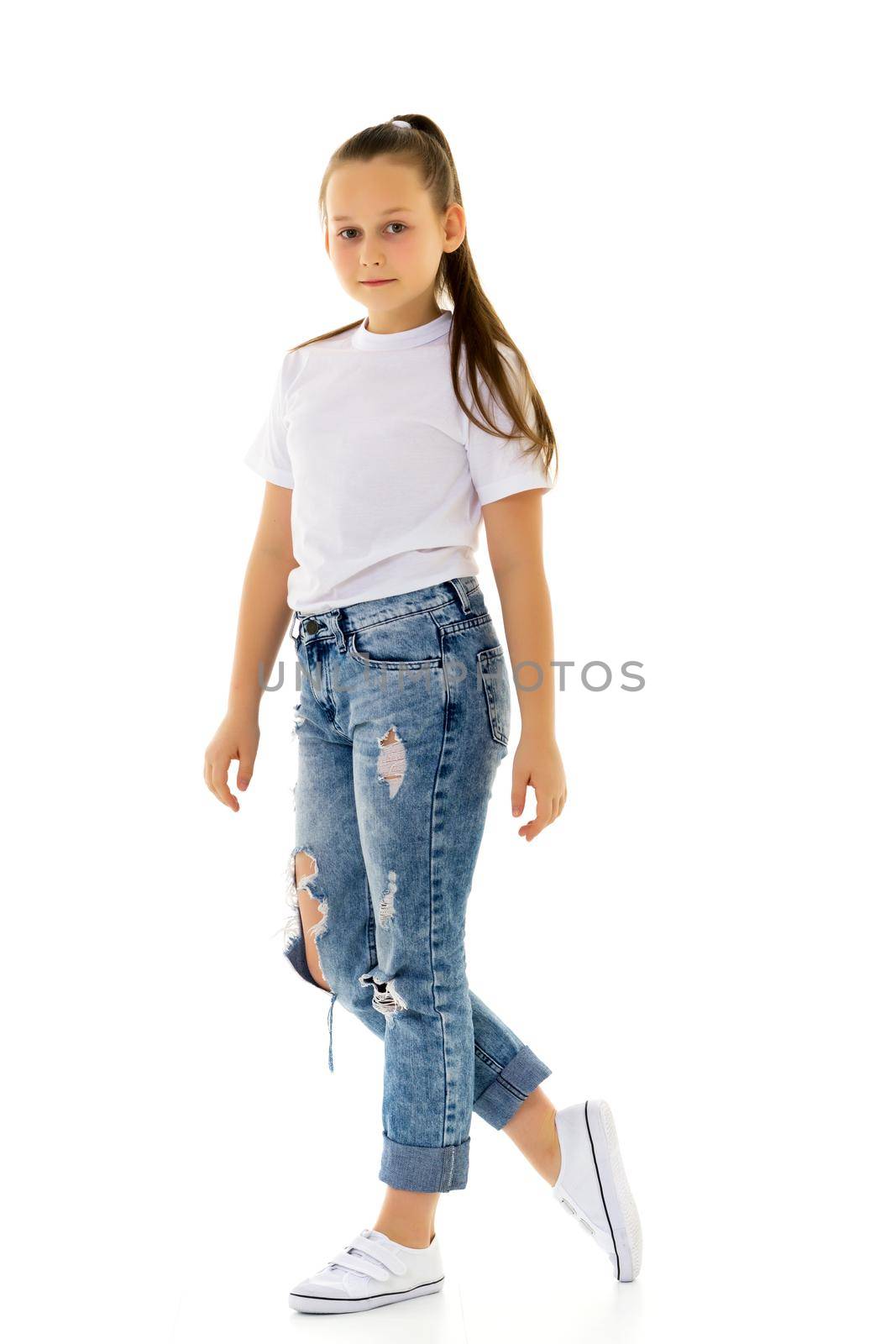 Portrait of a little girl close-up, in a clean white T-shirt and jeans. On the shirt you can put a logo or any other inscription.