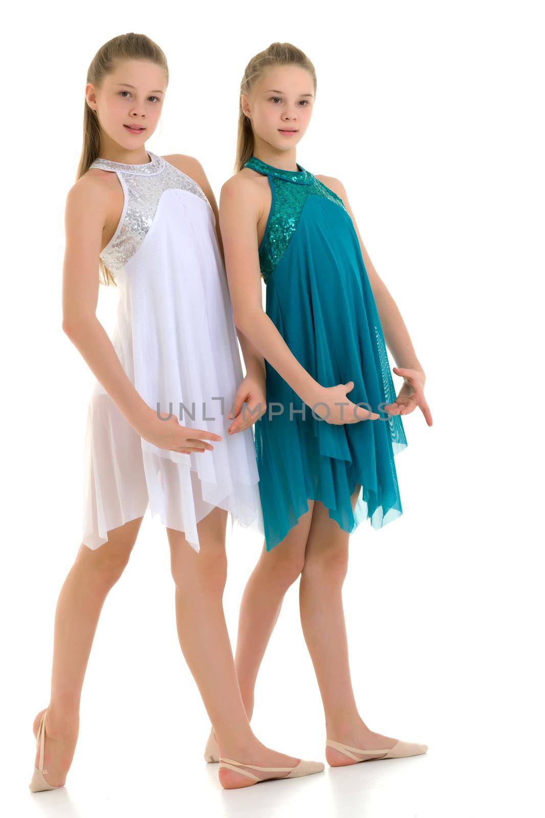 Pretty Graceful Ballet Dancers Performing in Studio, Two Beautiful Twin Sisters Dancing Wearing White and Blue Sport Dresses, Two Teenage Girls Posing in Studio Against White Background