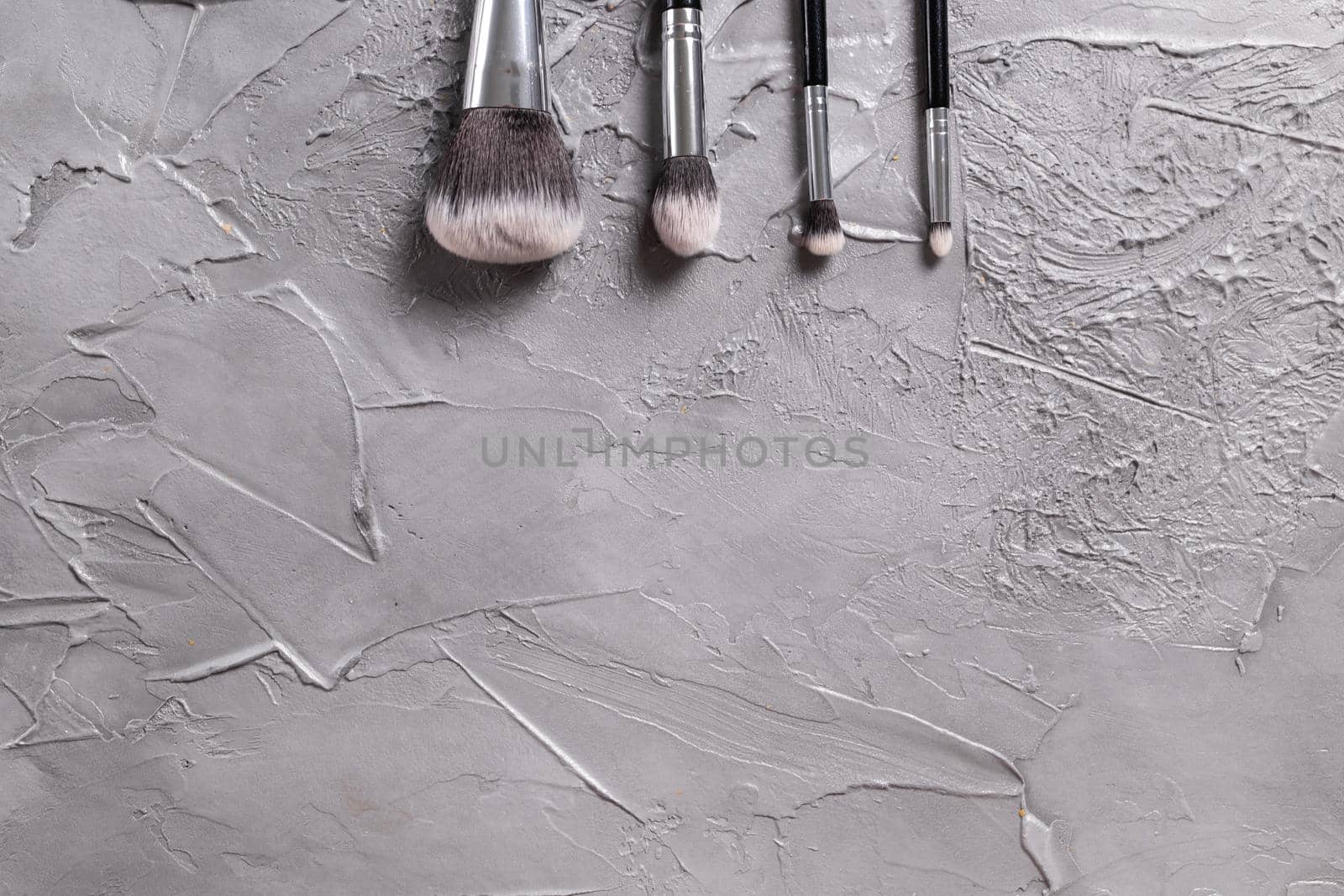 Top view of make-up brushes on grey background with copyspace by Satura86
