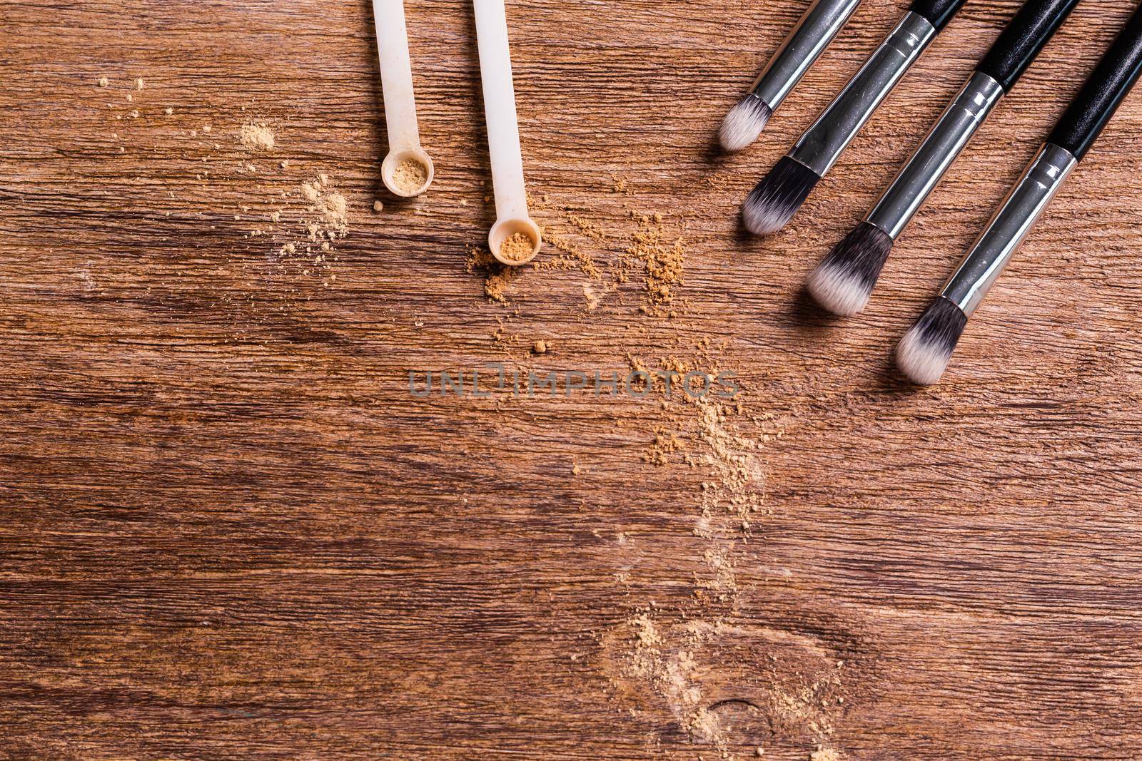 Mineral powder for face and a brushes for powder and visage on wooden background with copy space. Eco friendly and organic cosmetics. by Satura86