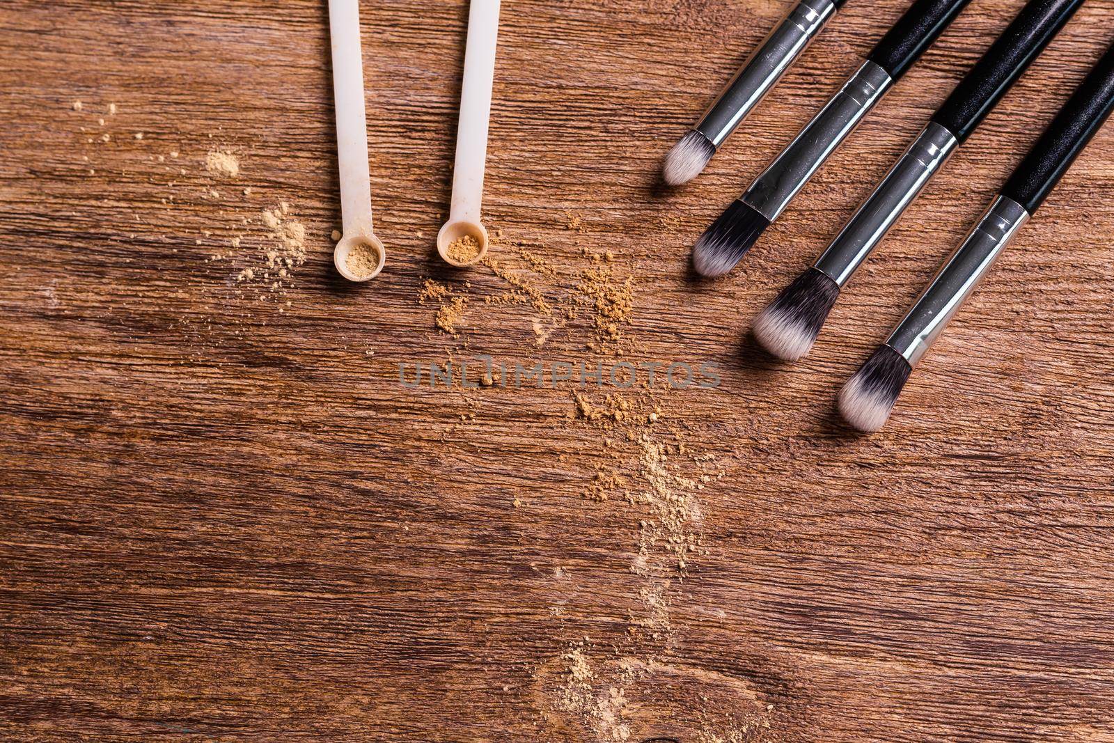 Mineral powder foundation with brushes on a wooden background with copy space. Eco-friendly and organic beauty products by Satura86