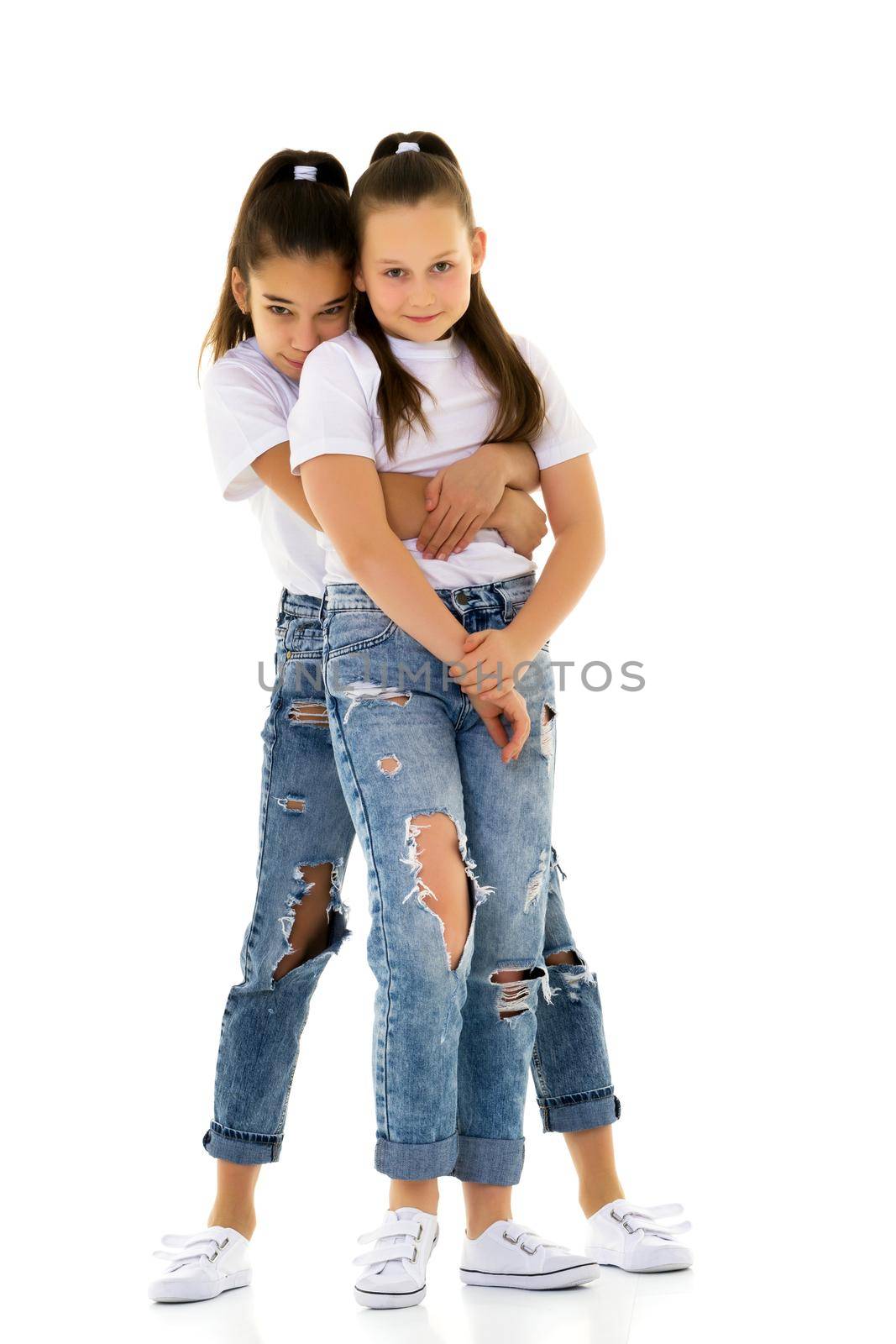 Two cute little girls in full growth, in the studio on a white background. The concept of a happy childhood, Beauty and fashion. Isolated.