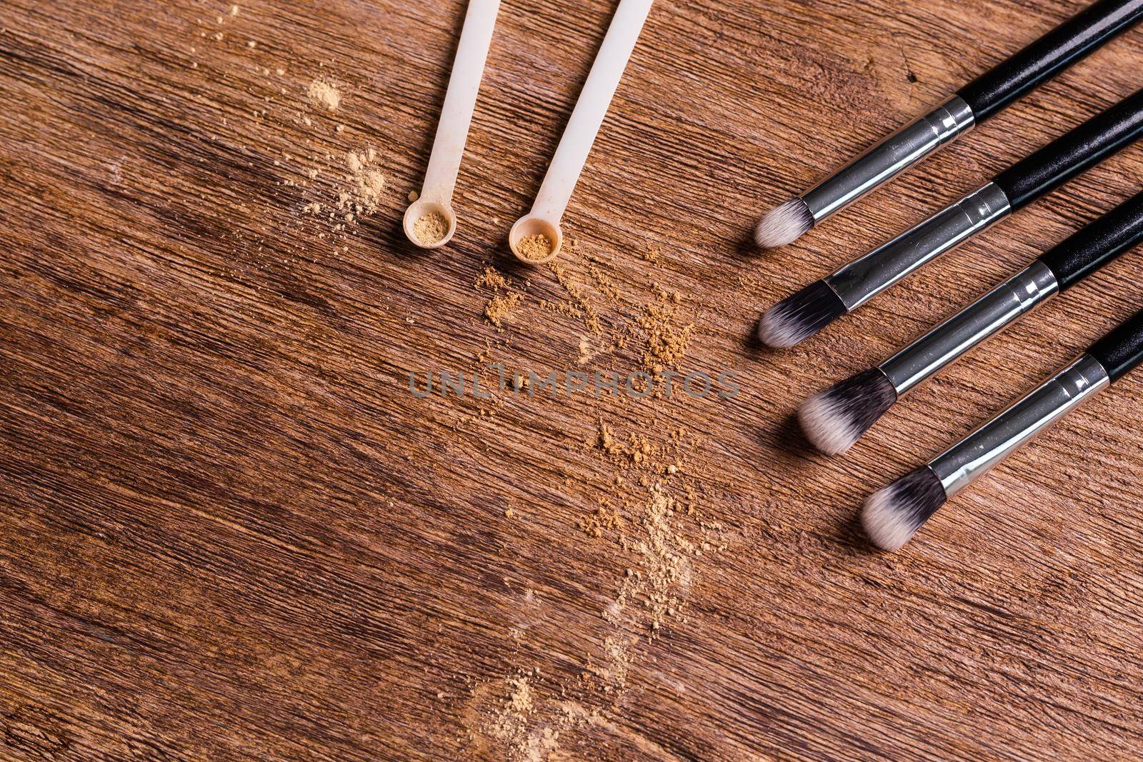 Mineral powder foundation with brushes on a wooden background with copy space. Eco-friendly and organic beauty products by Satura86