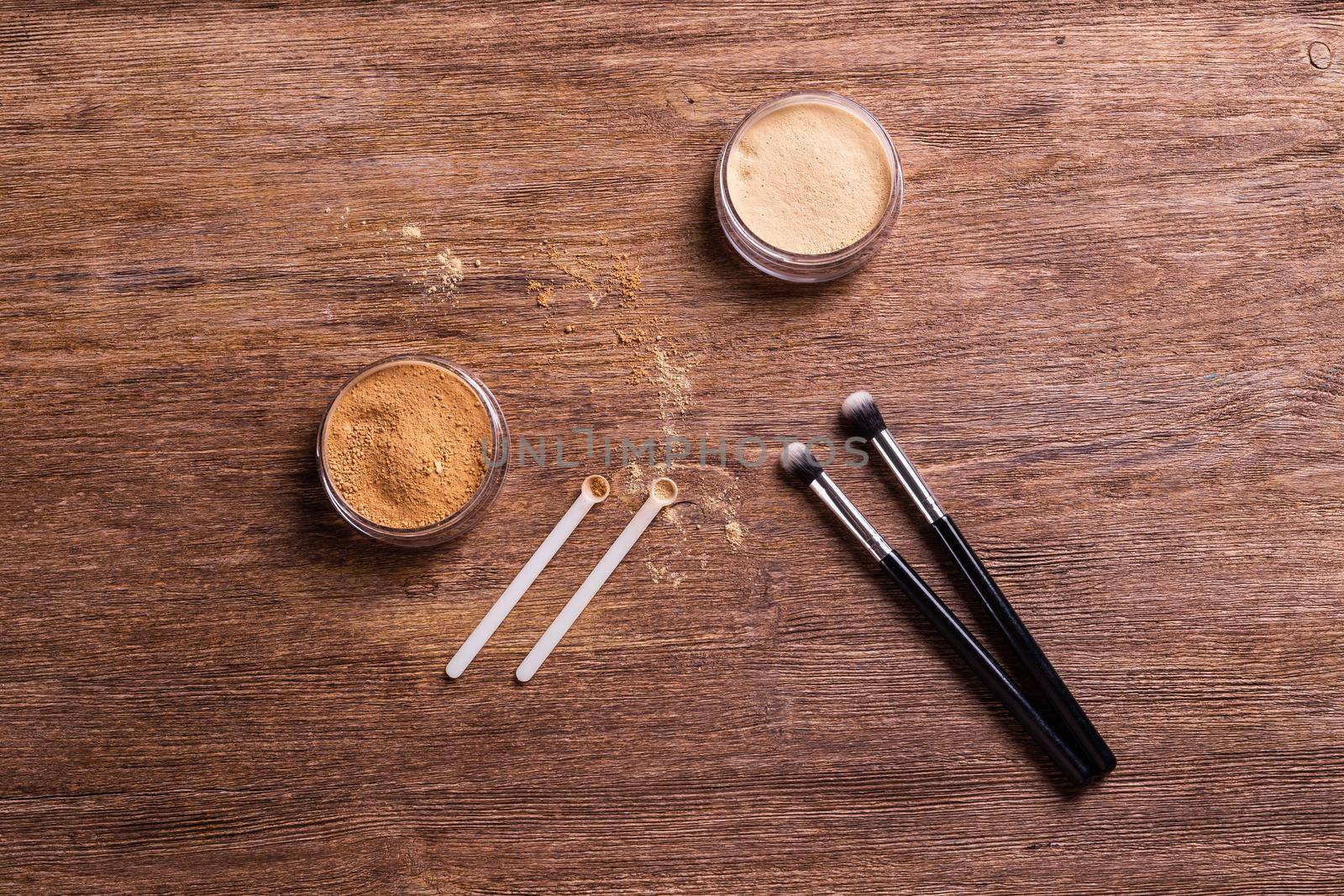 Mineral powder foundation with brushes on a wooden background. Eco-friendly and organic beauty products by Satura86