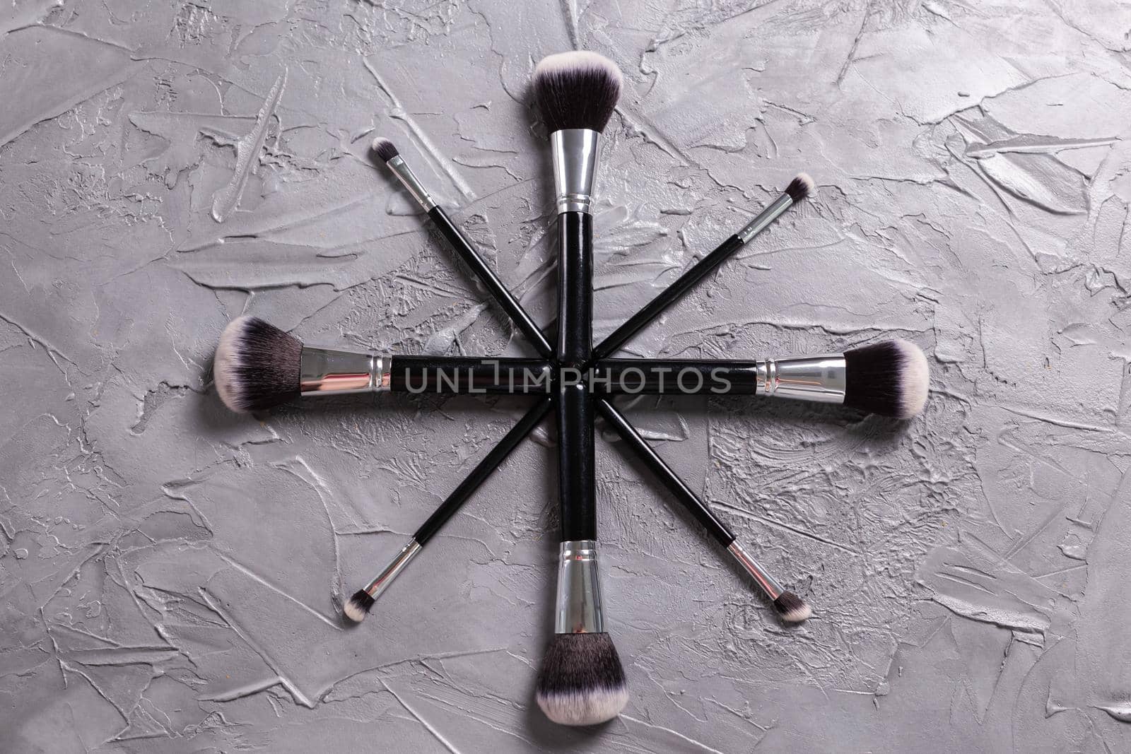 Top view of make-up brushes on grey background by Satura86