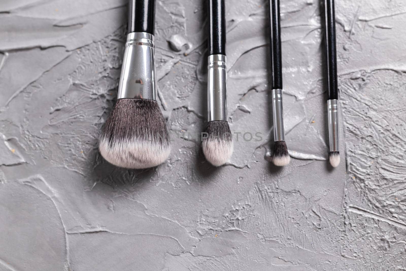 Top view of make-up brushes on grey background with copyspace by Satura86