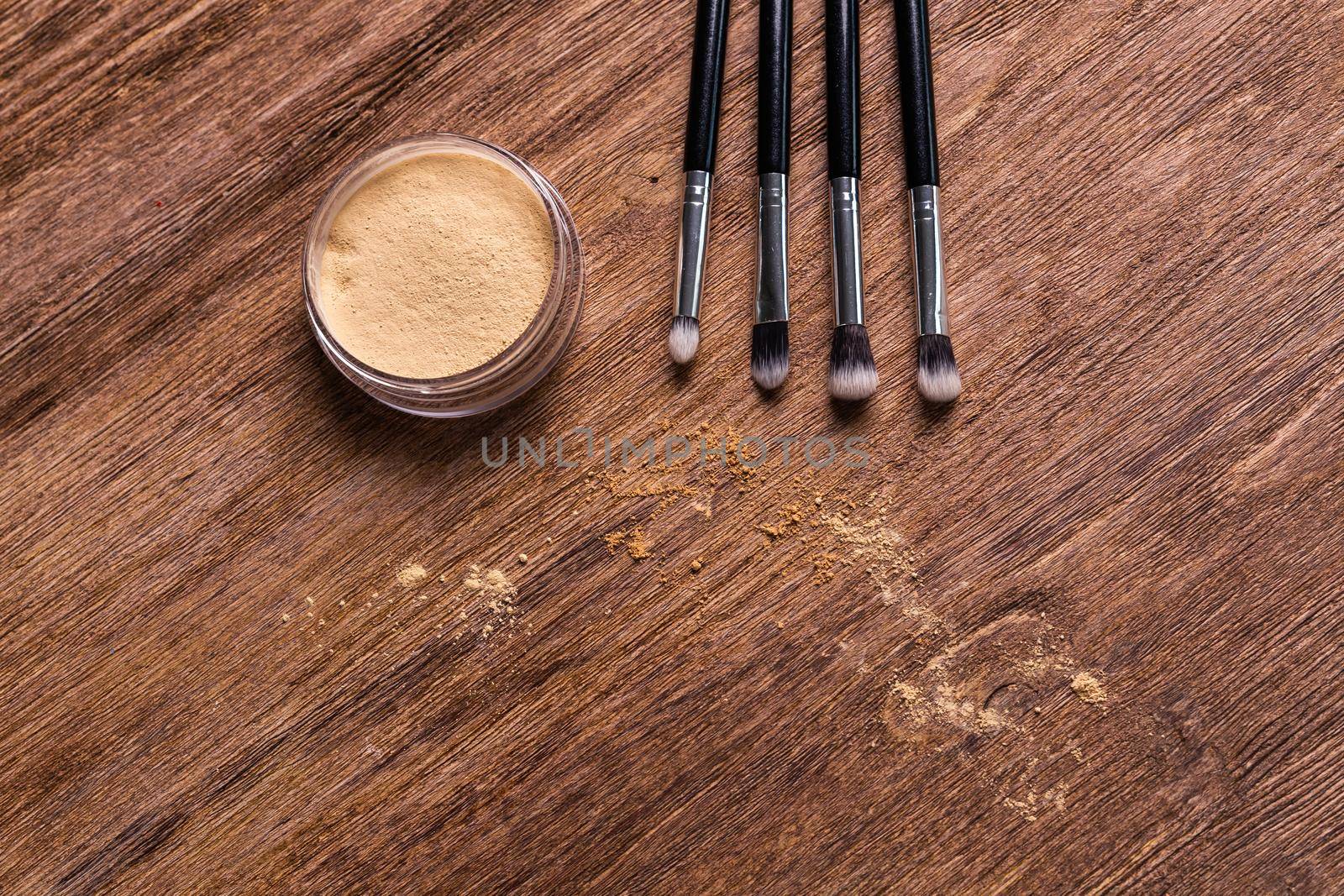 Mineral powder foundation with brushes on a wooden background with copy space. Eco-friendly and organic beauty products by Satura86