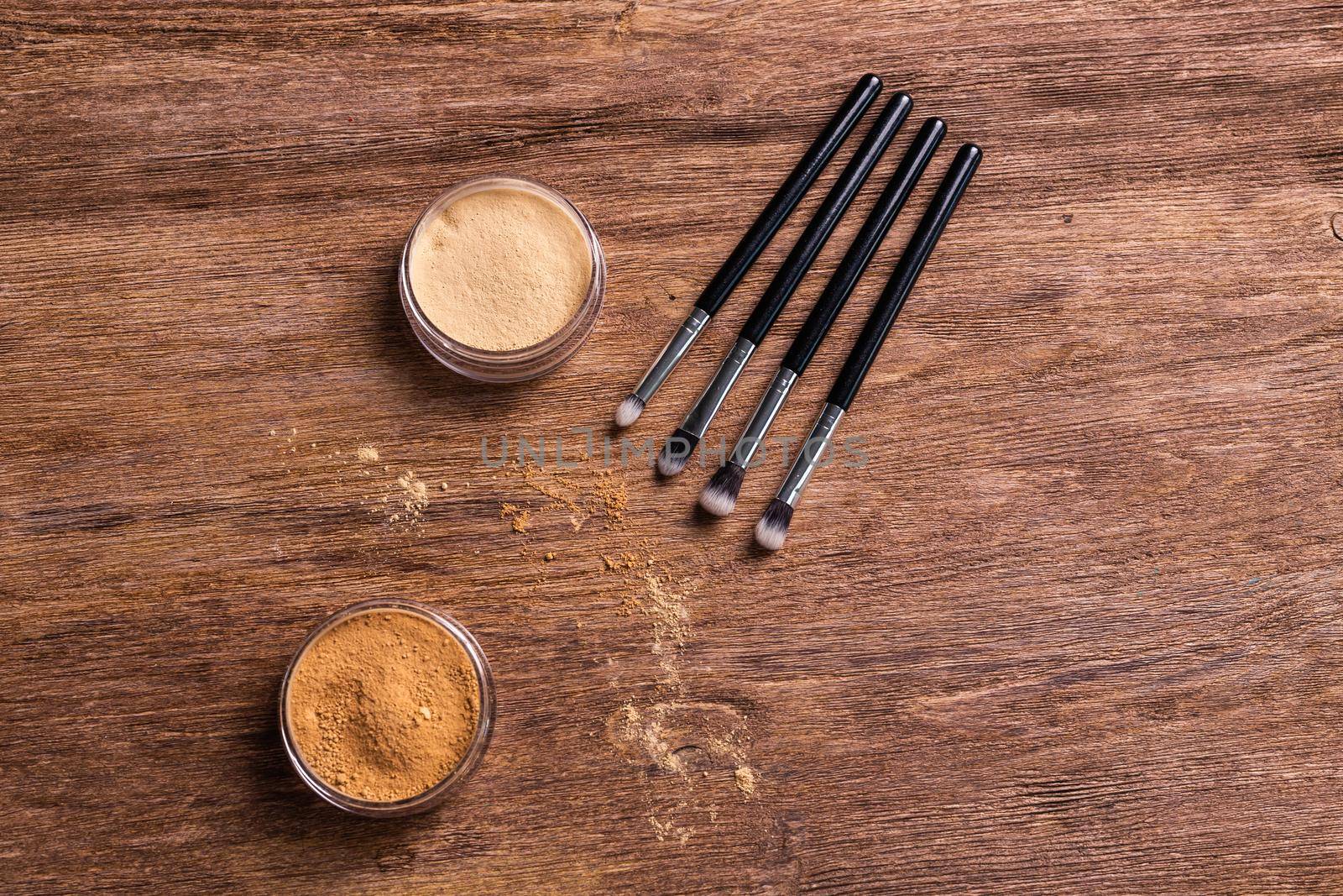 Mineral powder foundation with brushes on a wooden background with copy space. Eco-friendly and organic beauty products by Satura86