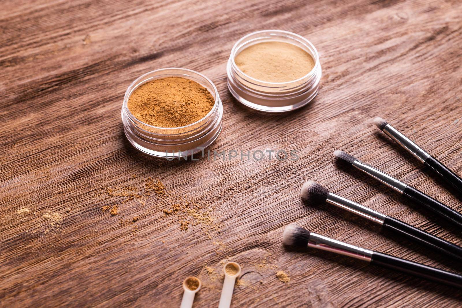 Loose compact mineral powder for face and a brushes for powder and visage on wooden background. Eco friendly and organic cosmetics. by Satura86
