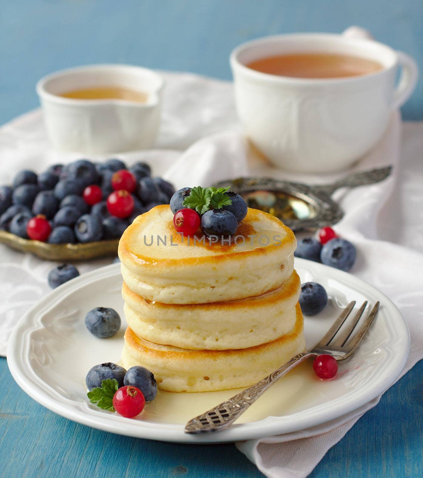 Stack of pancakes with fresh berries and honey