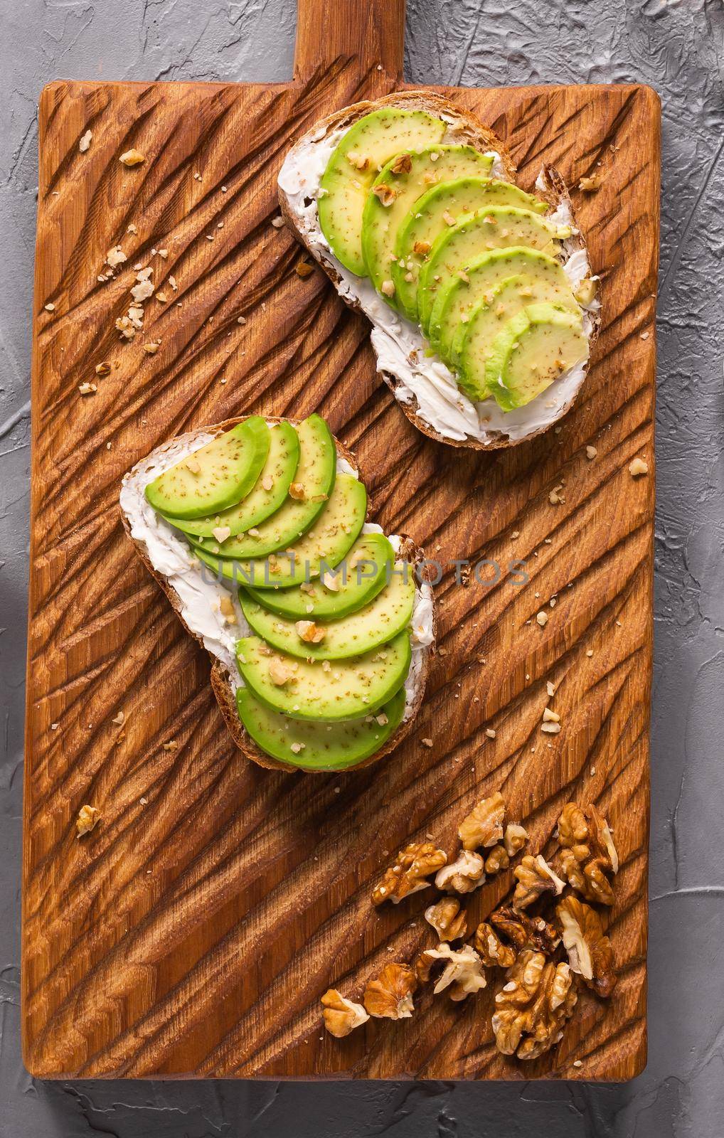 Sliced avocado on toast bread with nuts. Breakfast and healthy food concept. by Satura86