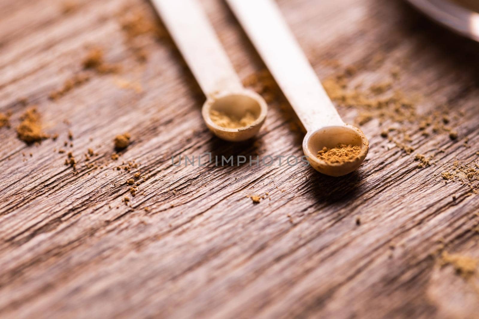 Mineral powder with a spoon dispenser for make-up on wooden background by Satura86