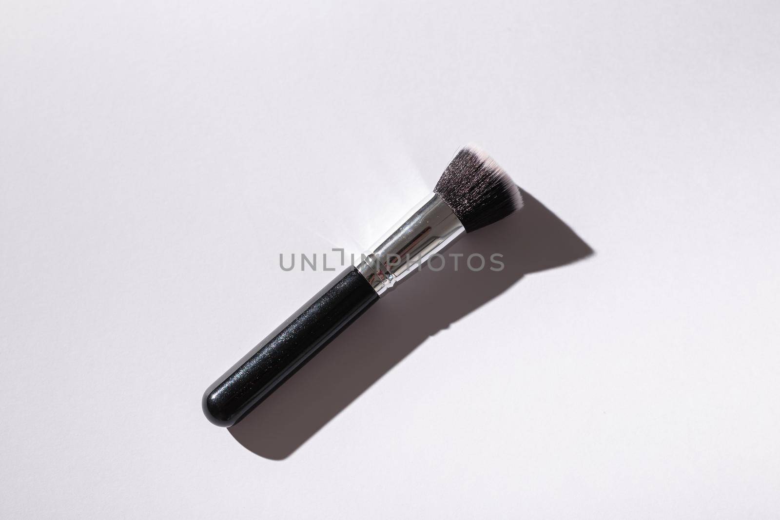 Make-up brush on white background, top view. Cosmetics, beauty and skin care concept