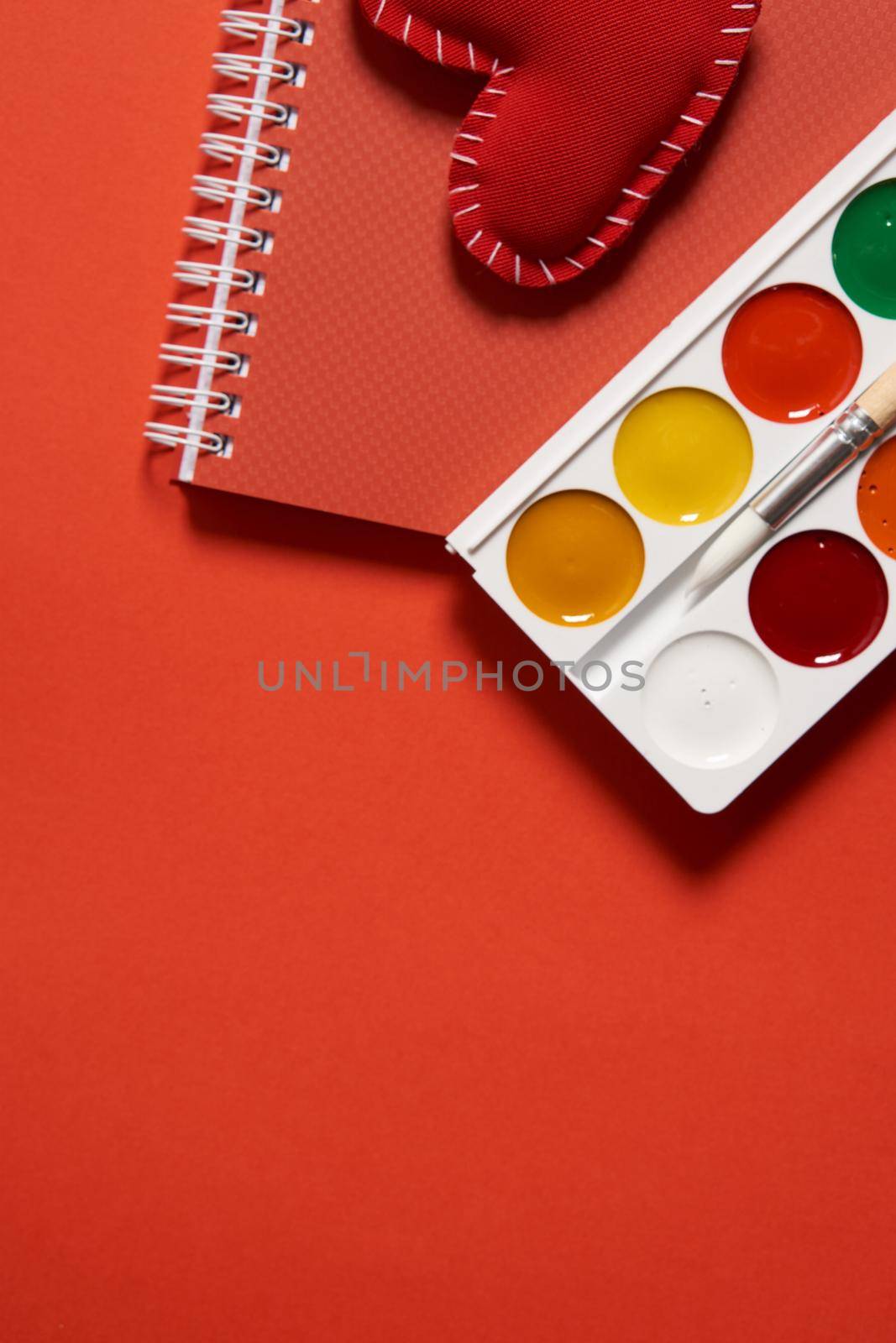 watercolor paint on red background drawing art supplies for artist. High quality photo