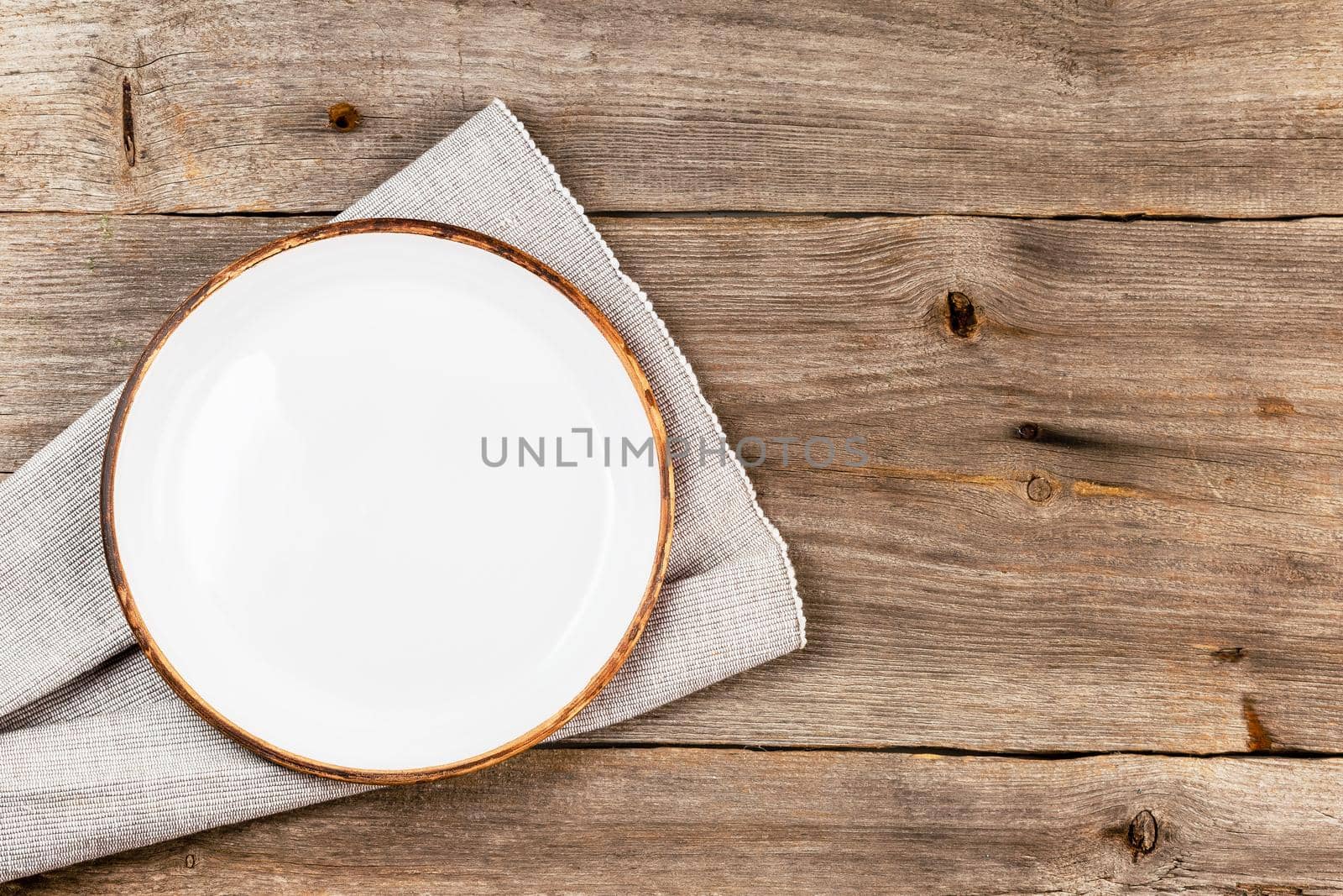 Empty white dish on rustic wooden table by Syvanych