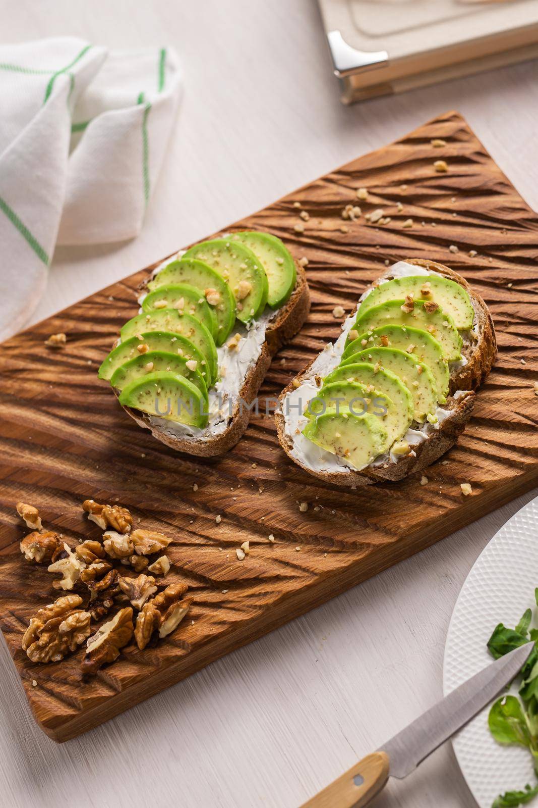 Avocado sandwich on dark rye bread made with fresh sliced avocados from above and nuts. Breakfast concept. by Satura86