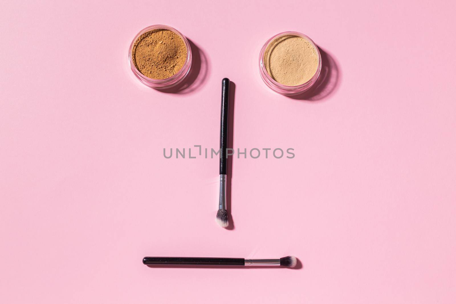 Various make-up brushes on pink background, top view. Cosmetics and beauty