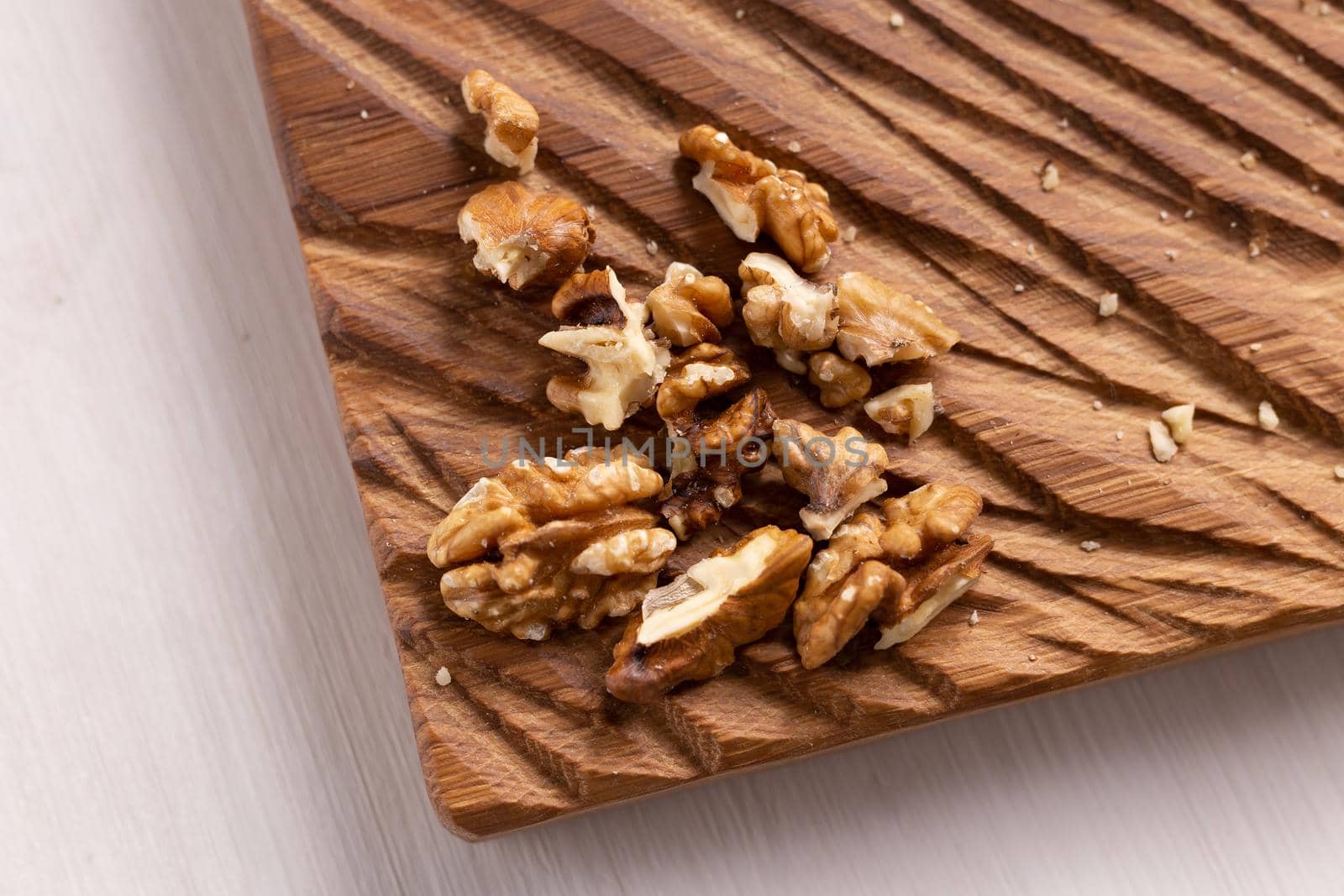 Walnut kernels on rustic board. Concept of healthy food and vegetarianism.