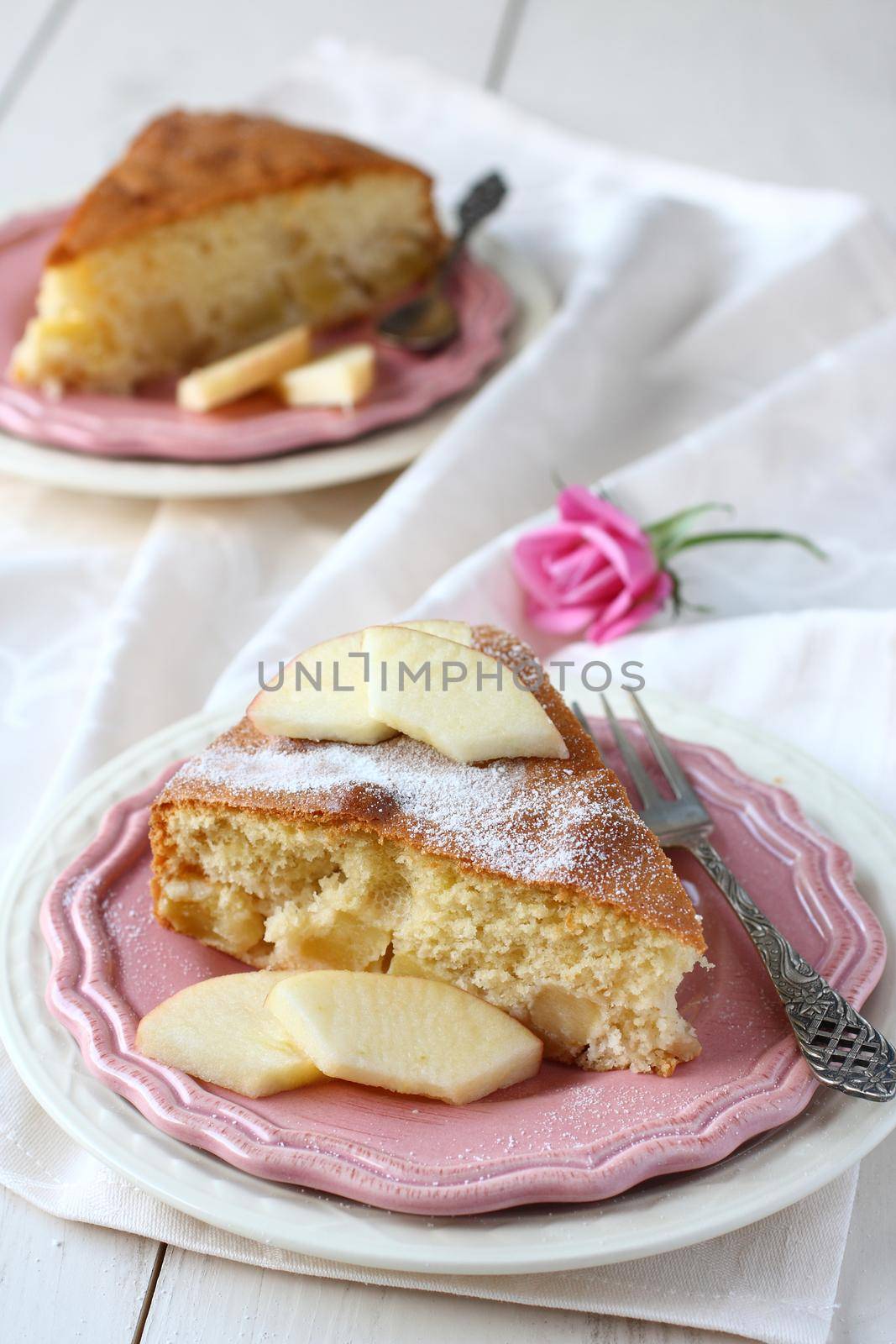 Slice of homemade apple sponge cake on pink plate