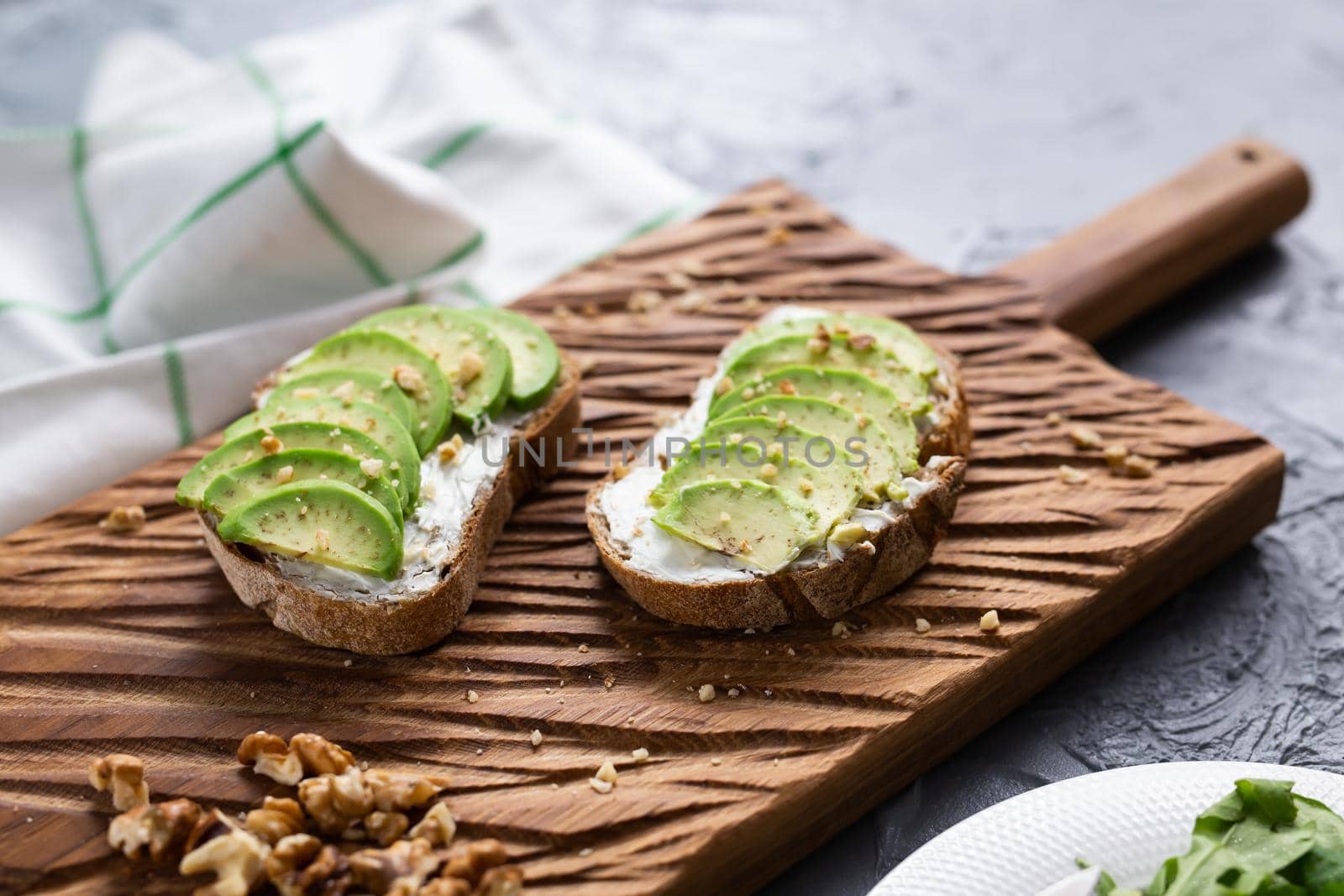 sliced avocado on toast bread with nuts by Satura86