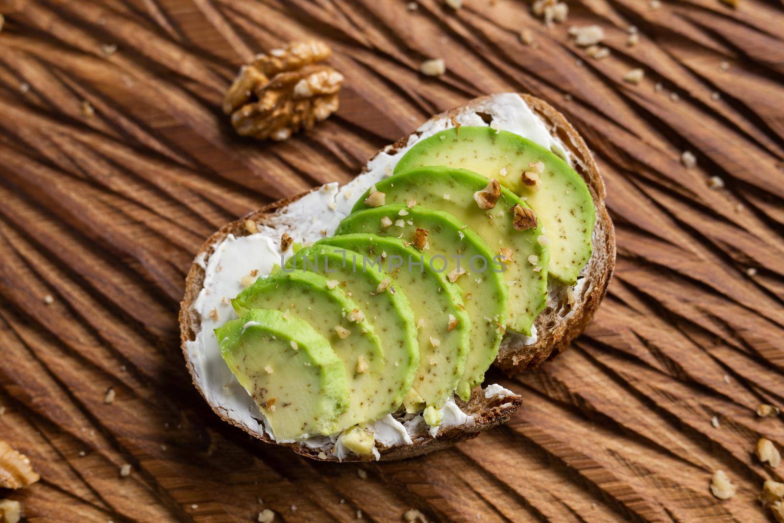sliced avocado on toast bread with nuts by Satura86