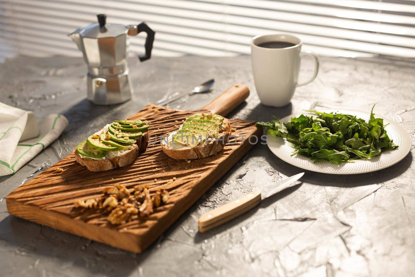 Sliced avocado on toast bread with nuts and coffee. Breakfast and healthy food concept. by Satura86