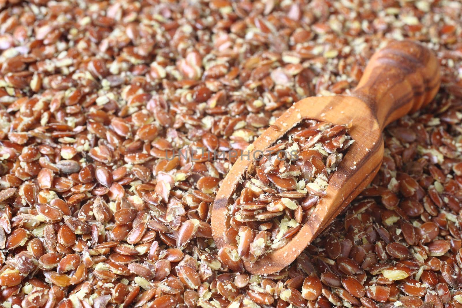 Broken flax seeds in wooden scoops (contain a lot of fibre)