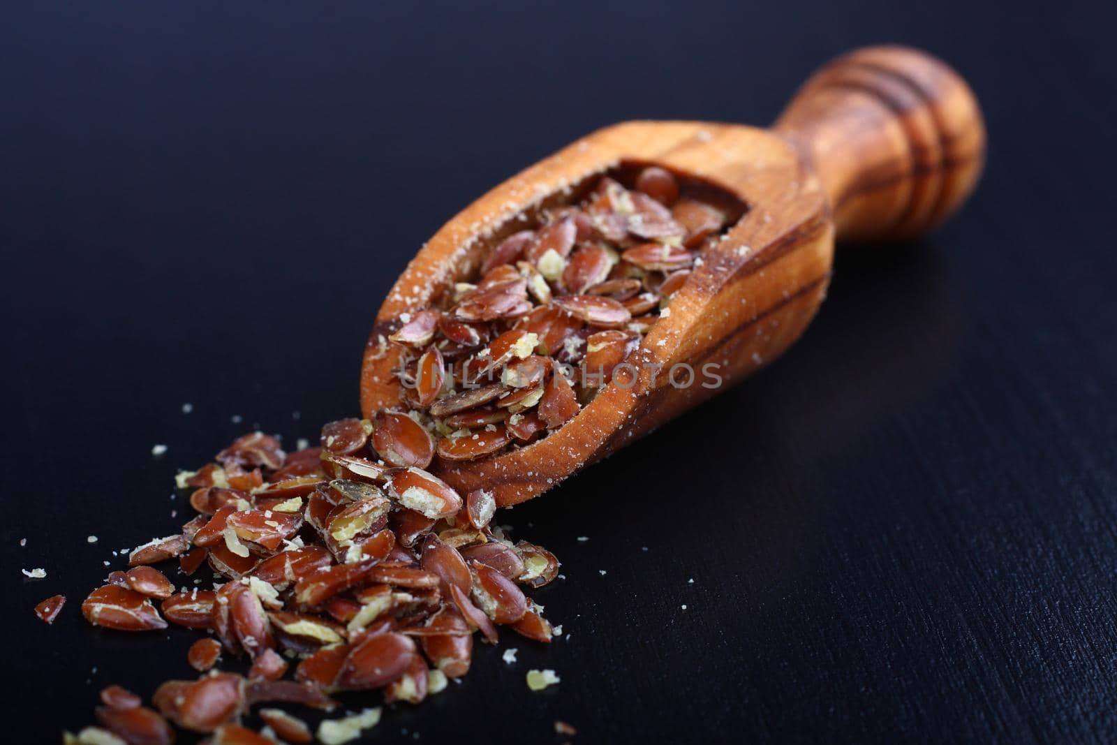 Broken flax seeds in wooden scoops (contain a lot of fibre)