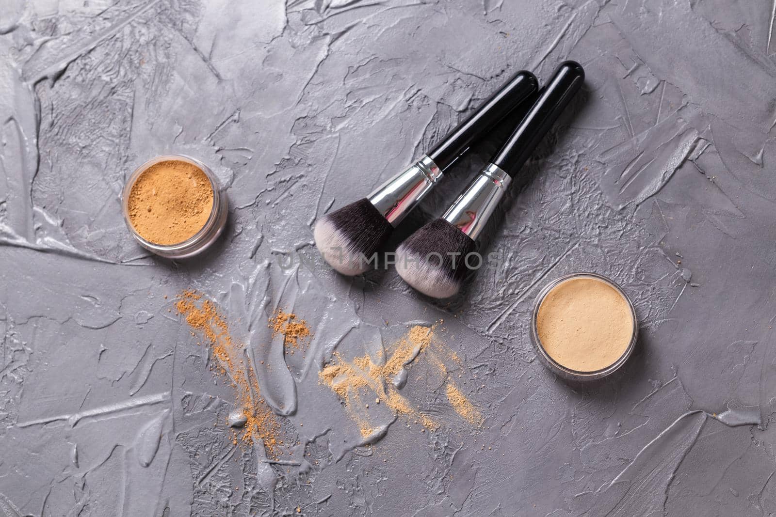 Mineral powder of different colors with a brushes for make-up on wooden background