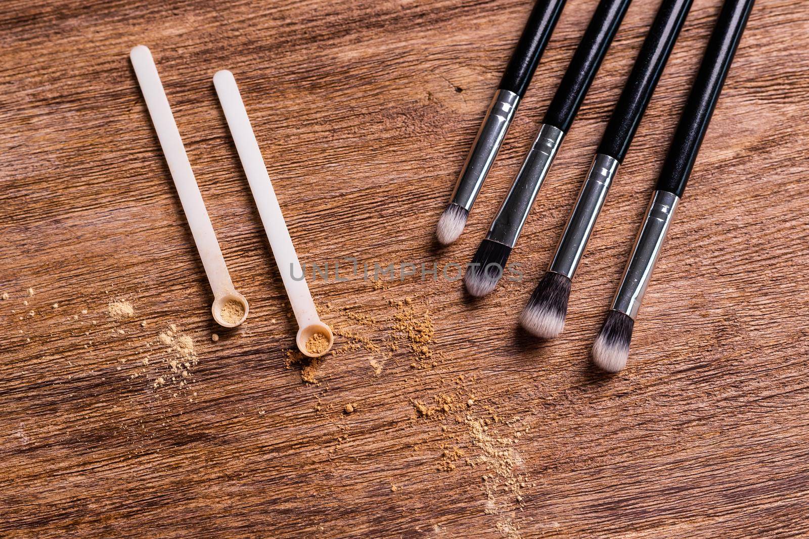Mineral powder foundation with brushes on a wooden background. Eco-friendly and organic beauty products by Satura86
