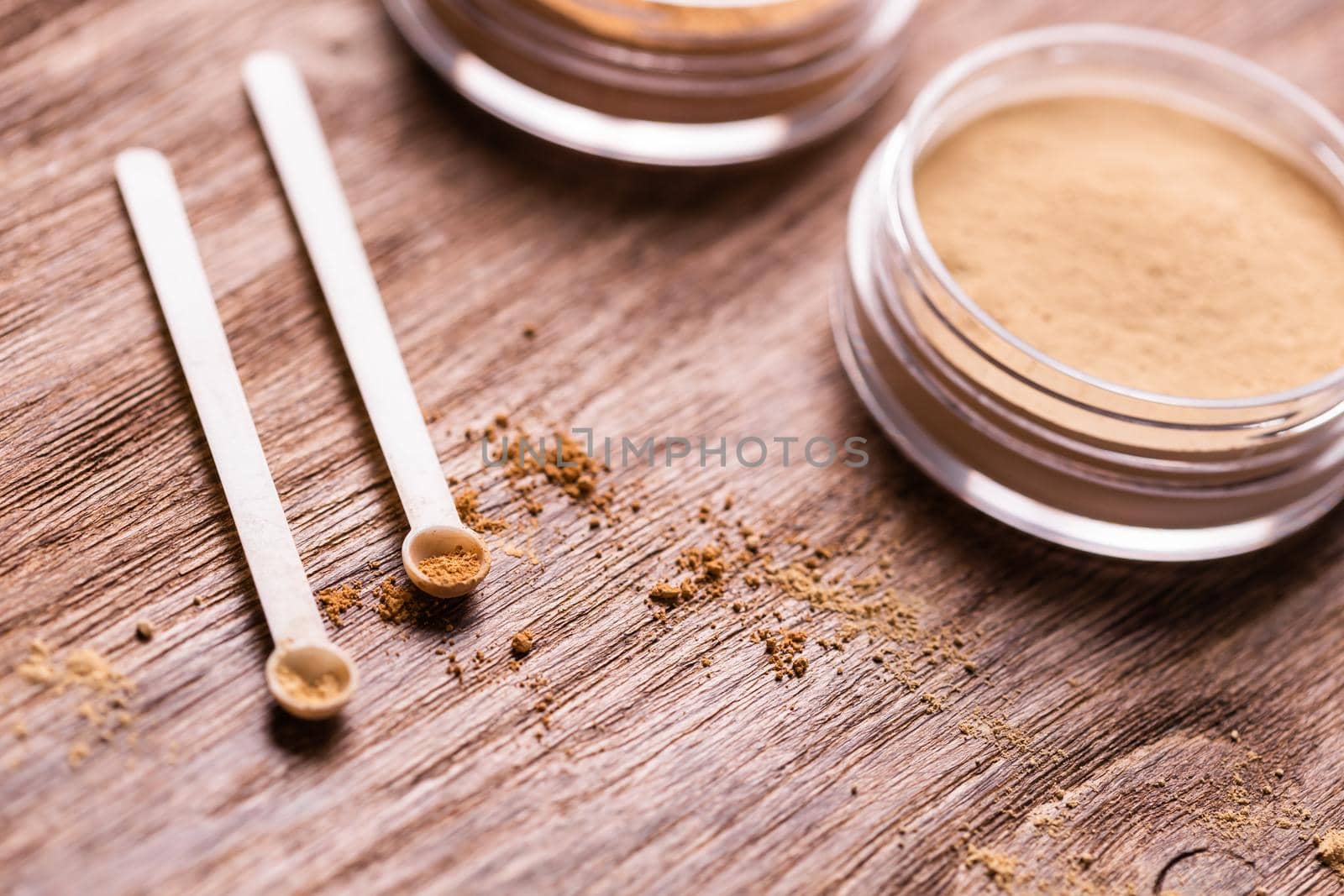 Mineral powder of different colors with a spoon dispenser for make-up on wooden background by Satura86